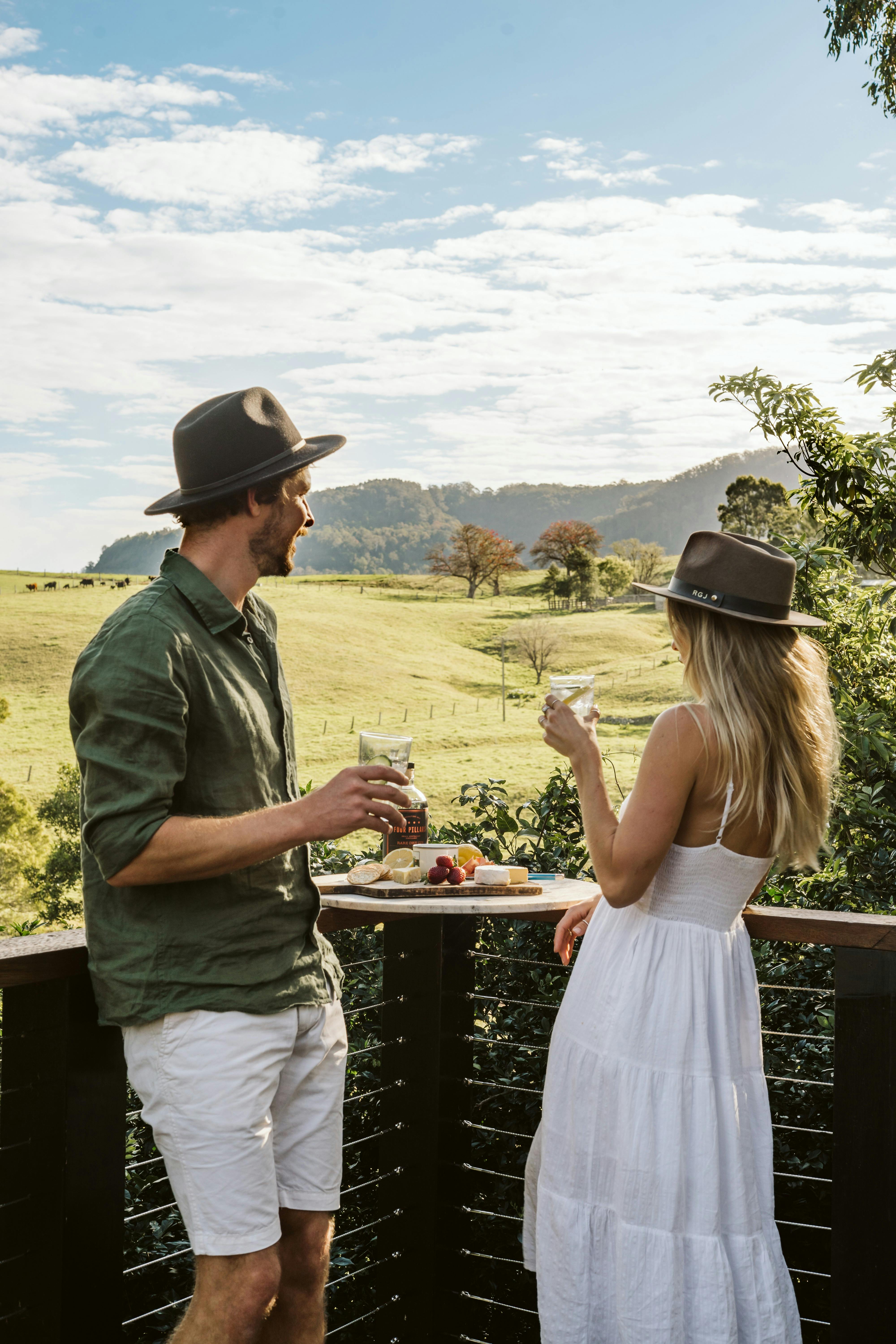 Image of a couple enjoying a drink and platter on the deck overlooking the hills and property