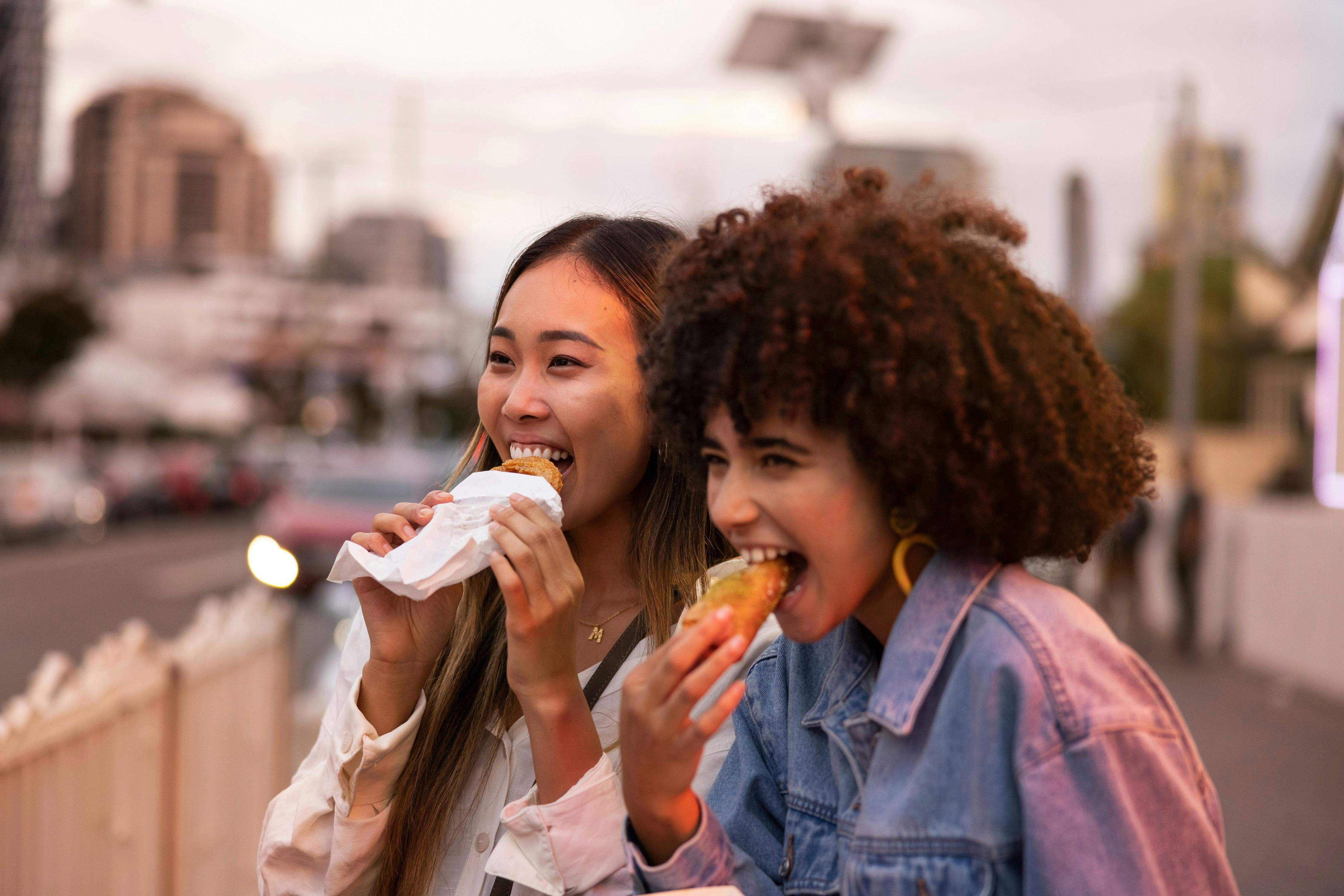 Friends enjoying takeaway food and drink in Little India in Harris Park