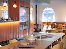 Interior seating area with bar, tables and warm lighting inside Macs Hotel