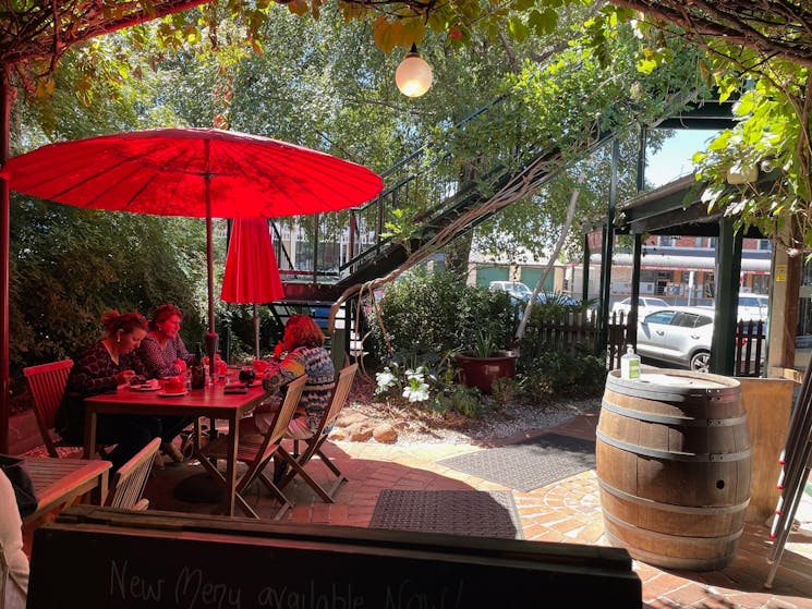 Red umbrella and guests in the leafy courtyard