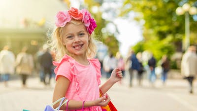 Young blonde girl smiling while shopping at an outdoor market