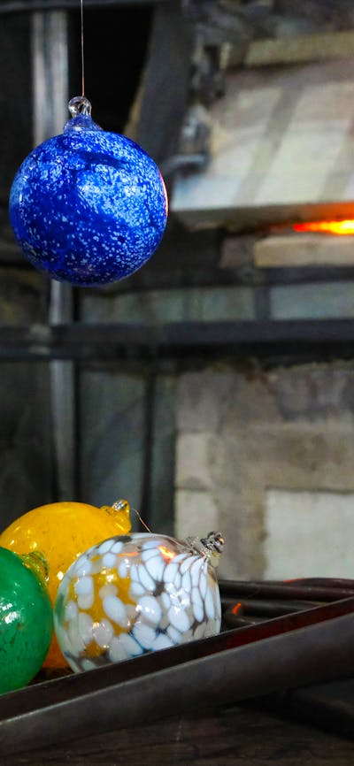 Glass baubles with glass blowing tools in the Hotshop