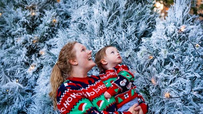 Women with baby admiring white Christmas trees