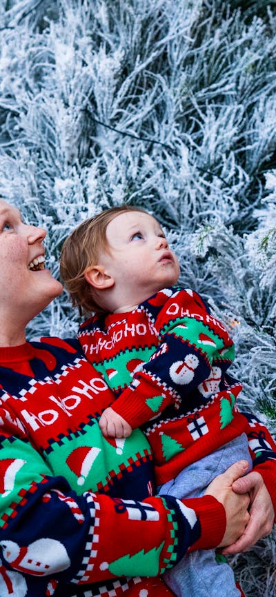 Women with baby admiring white Christmas trees