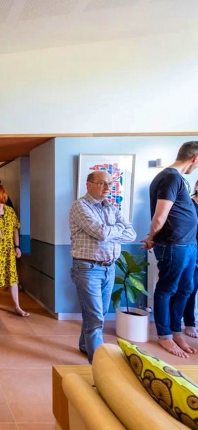 A group of people touring inside a home in the kitchen with bare feet