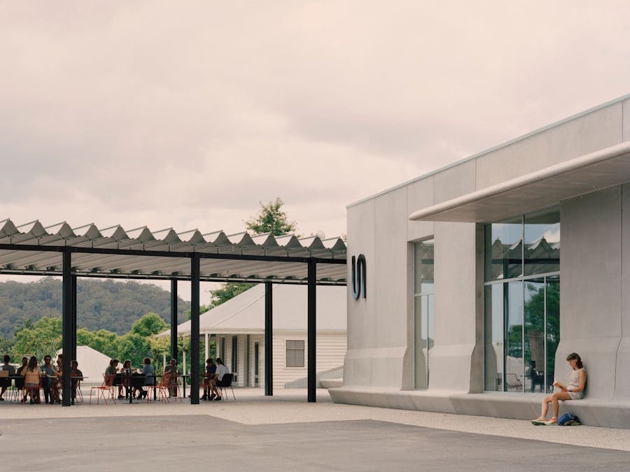 The concrete facade of the Art Museum and visitors enjoying their meals in the Ramox Cafe forecourt