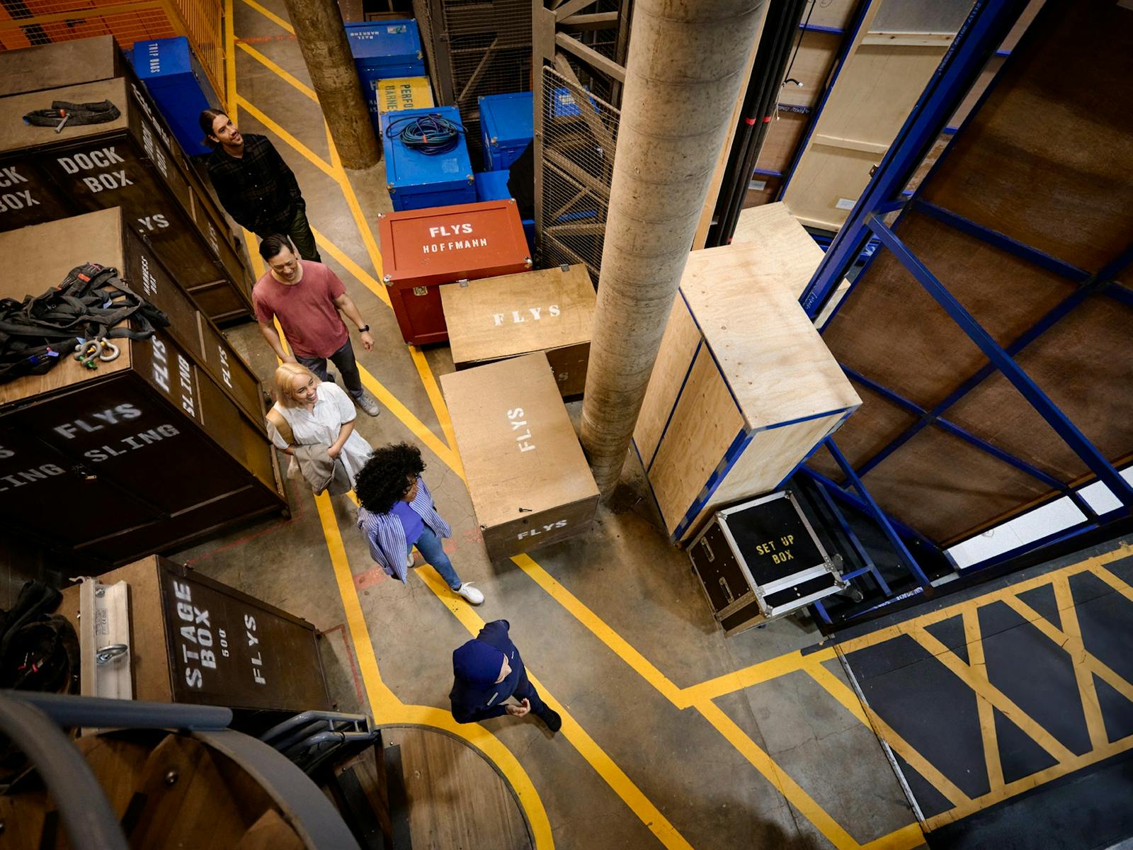 オペラハウスの舞台裏を歩くツアーグループを見下ろす