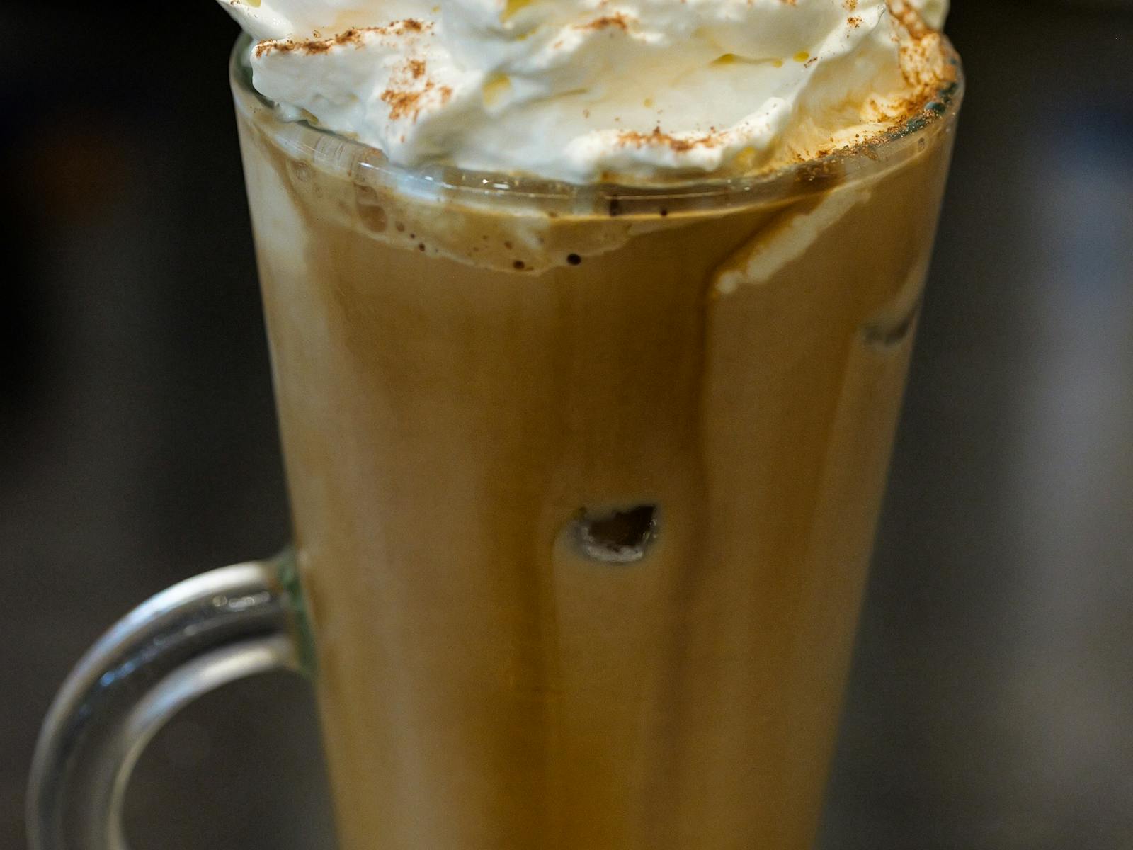 Tall glass of iced coffee with whipped cream and chocolate on top