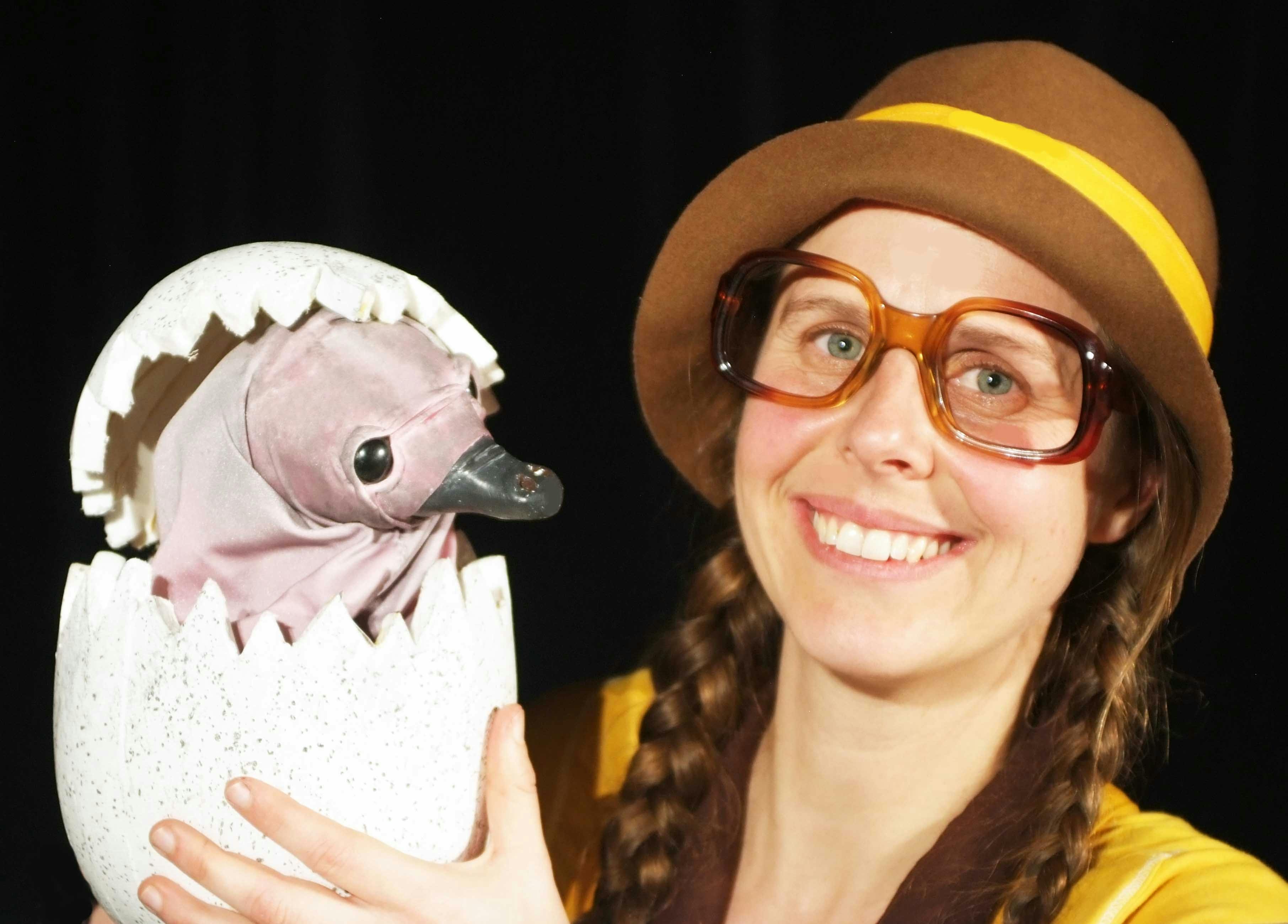 Girl with glasses holding a baby echidna puppet