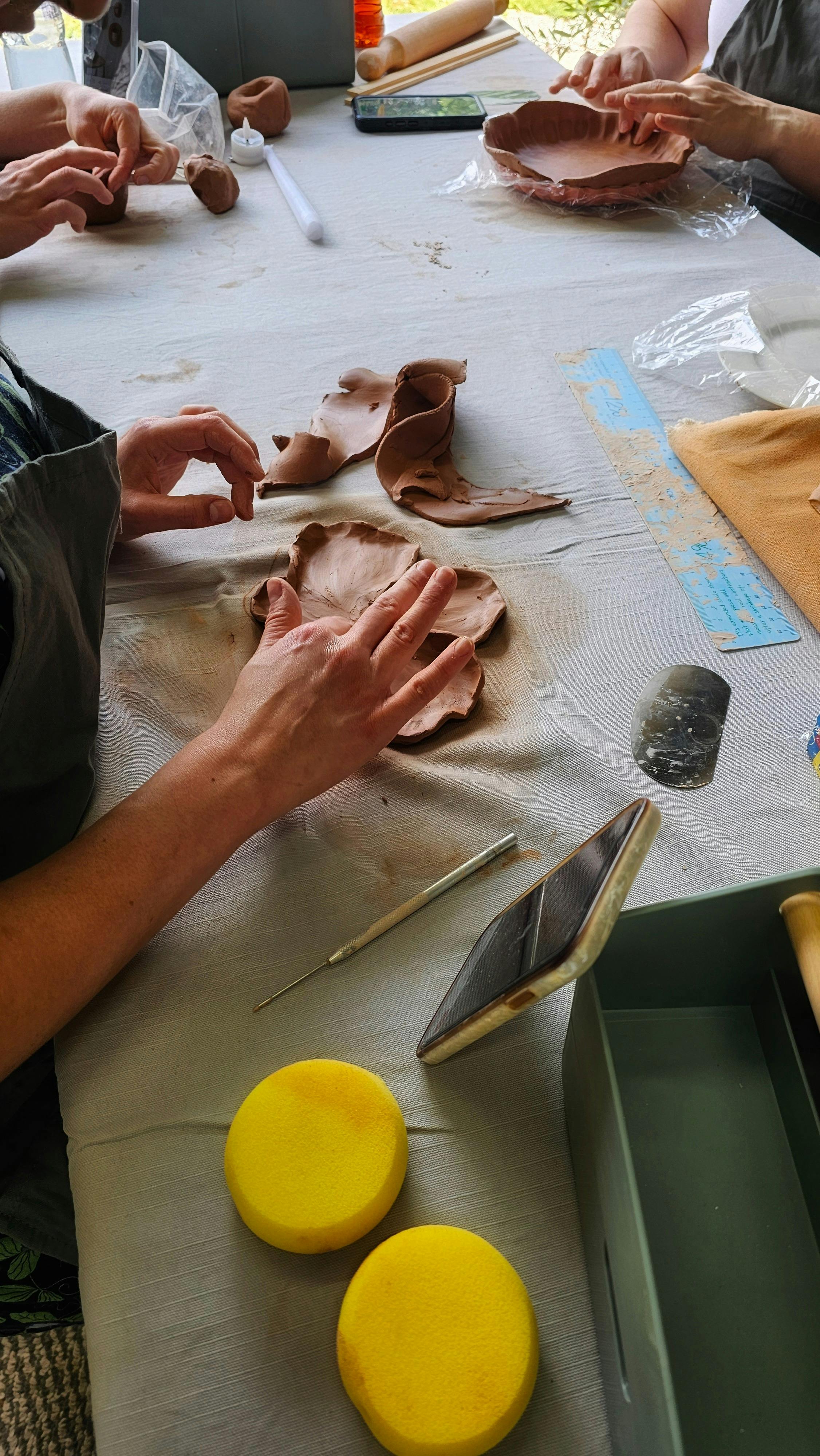 Hands sculpting a flower tray