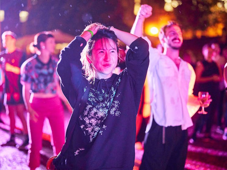 A person dancing at night with a joyful expression