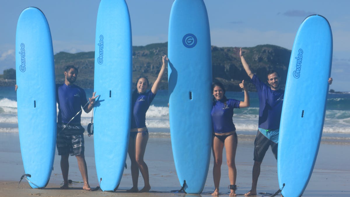 Surf crew lined up with their boards, all smiles!