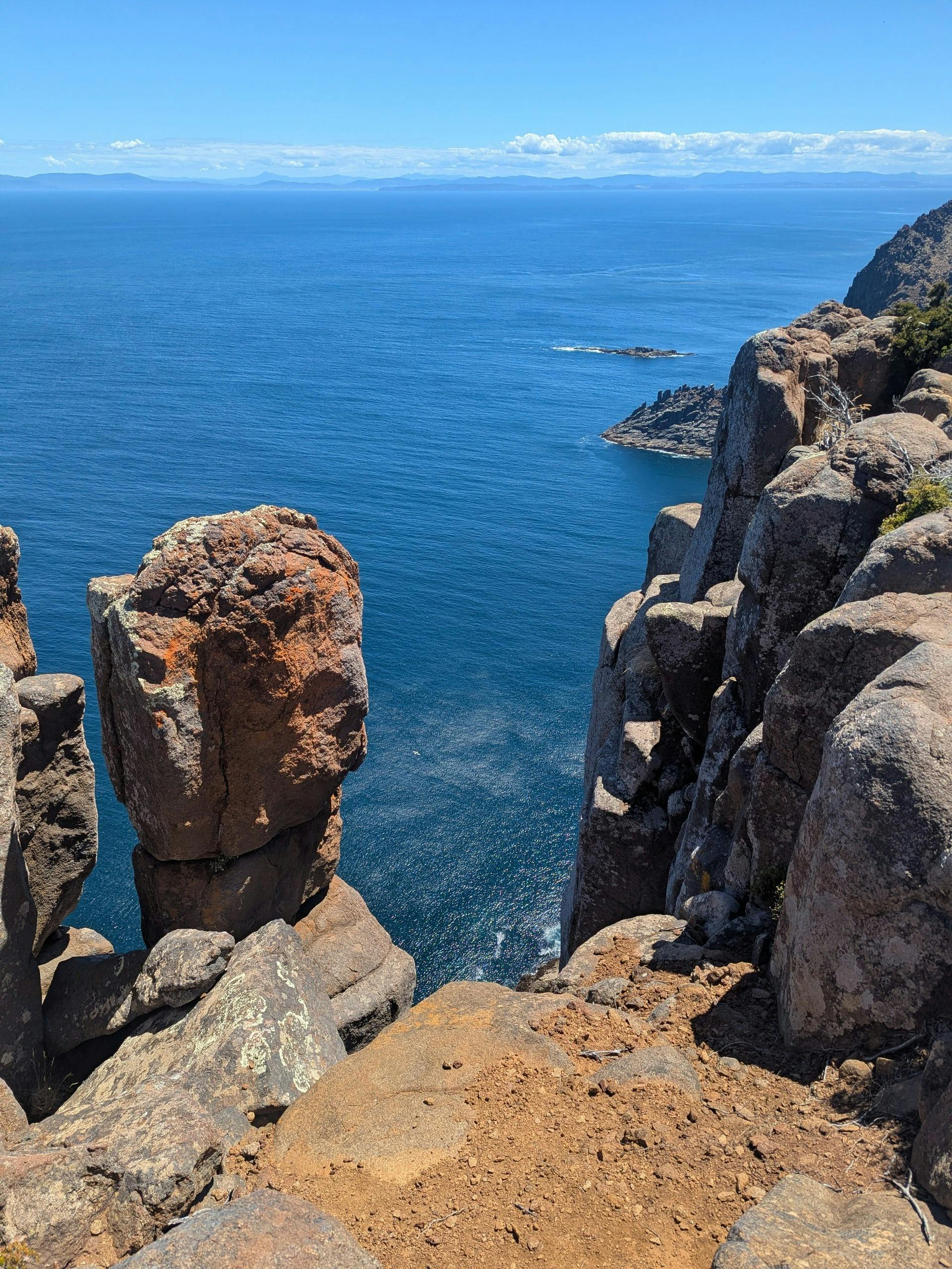 Dramatic rock formations and sea stacks along the Three Capes Walk Tasmania coastal track