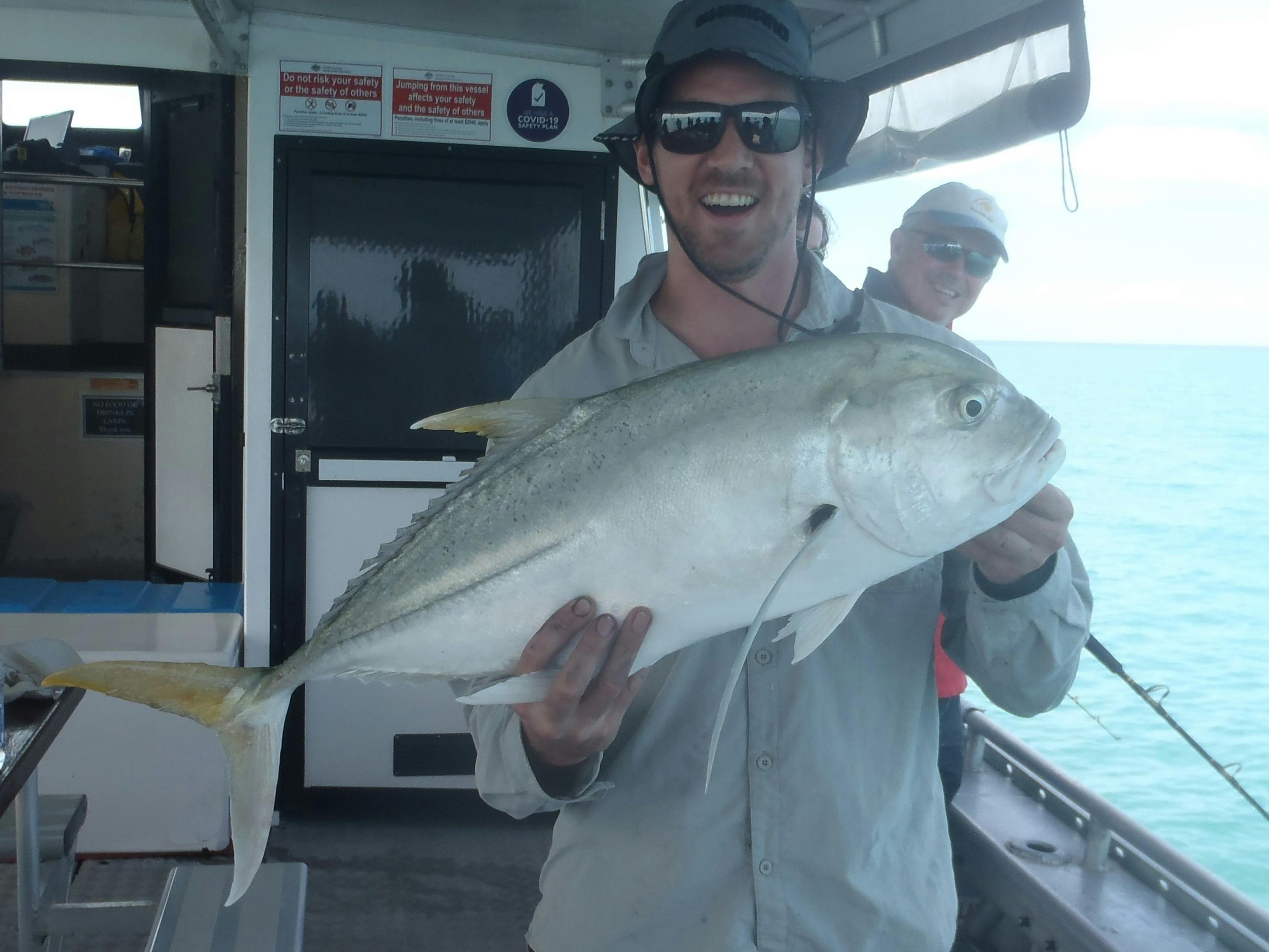 Guy catches a Queenfish on a Bluewater fishing charter