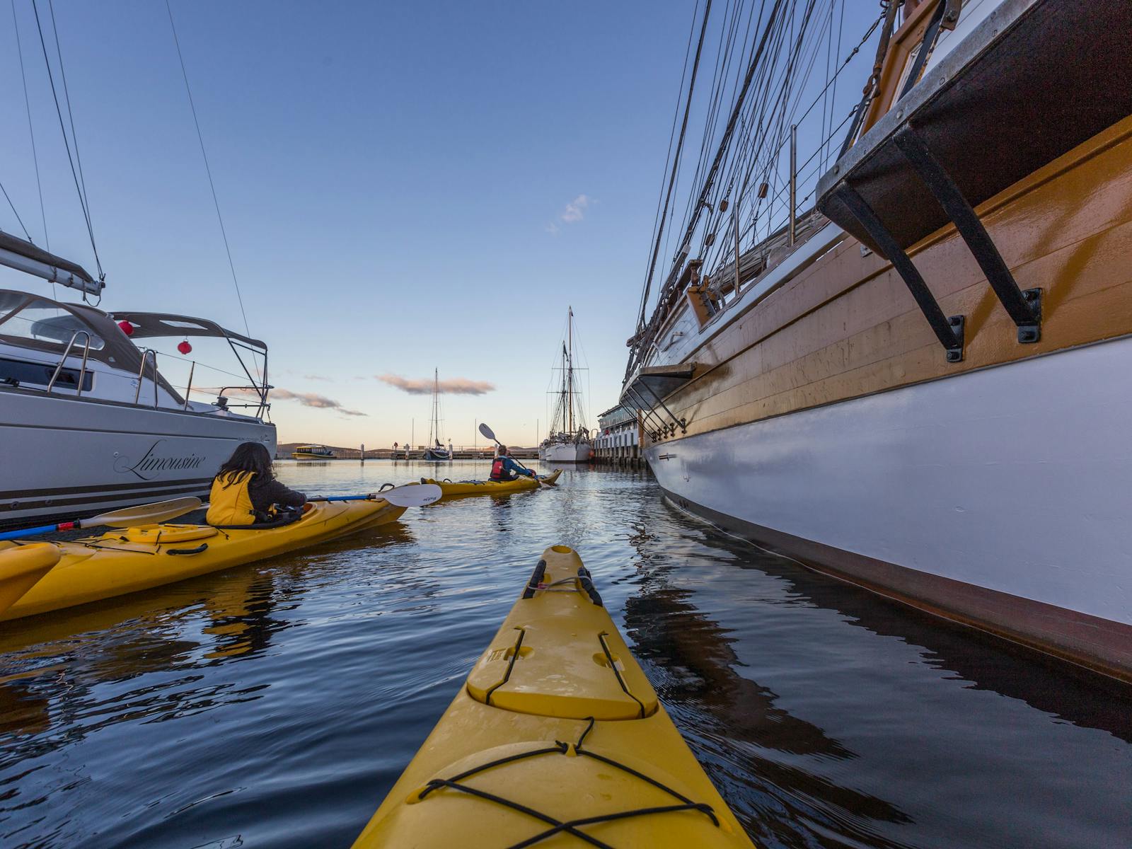 Kayakers paddling amongst the boats on the Hobart waterfront