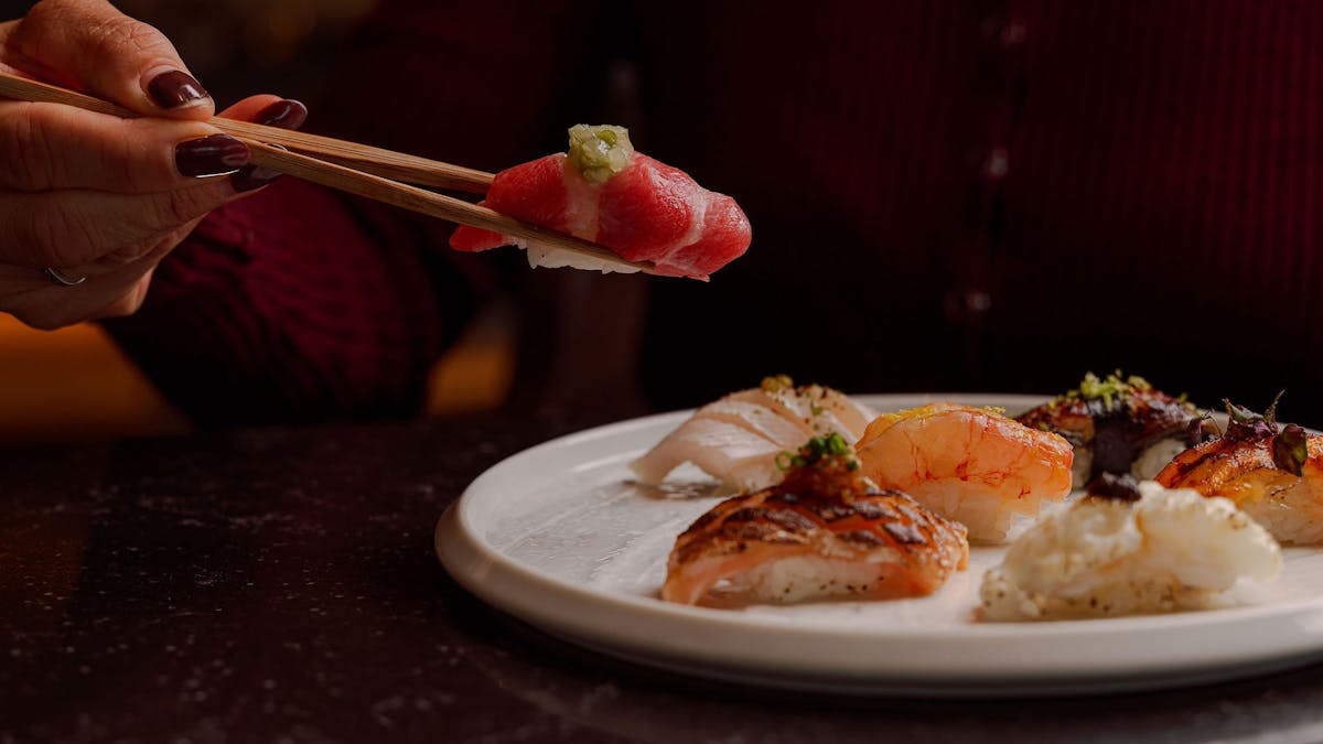 Chopsticks picking up a piece of sushi