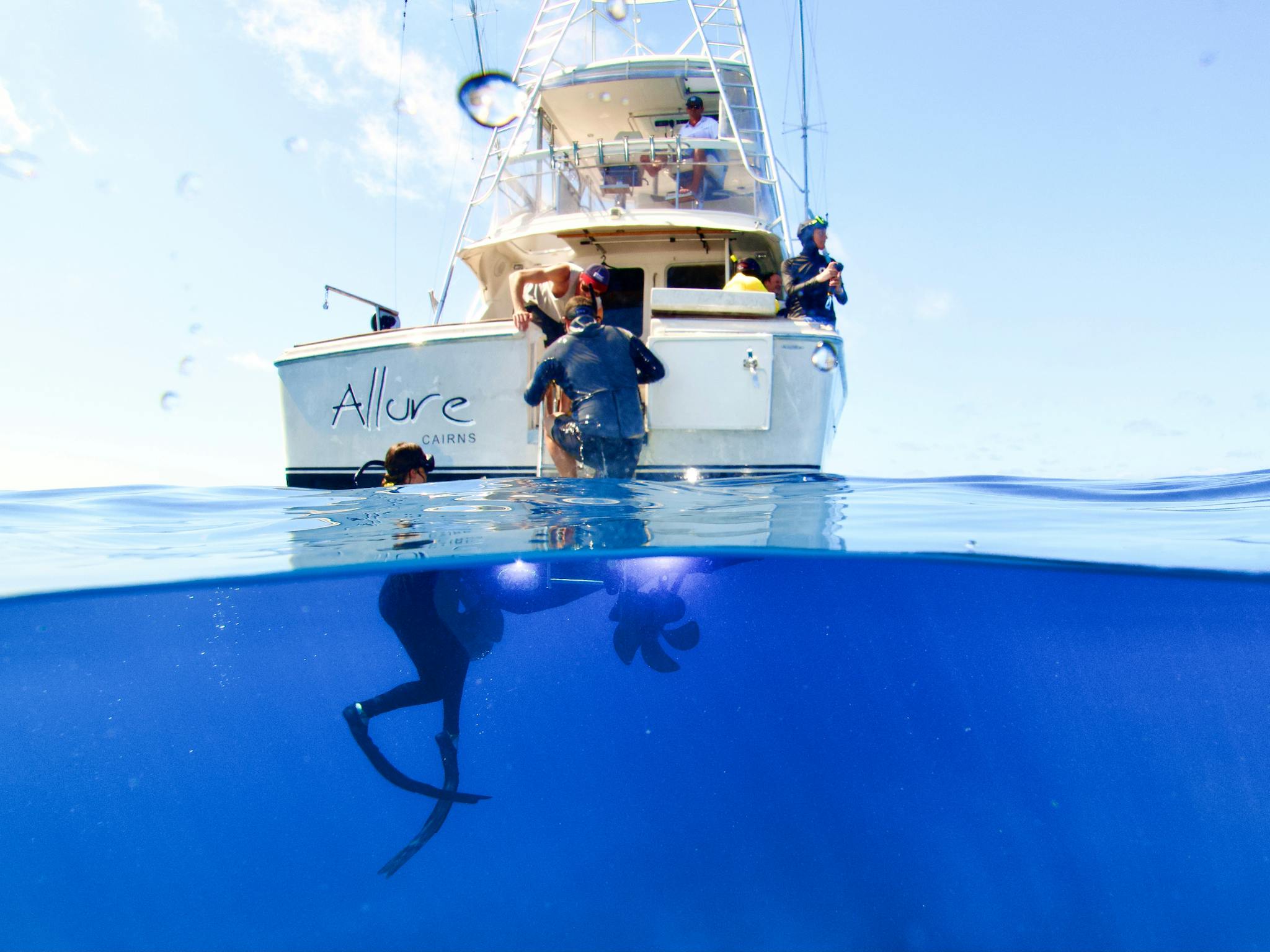 Snorkelers in clear blue water boarding charter boat Allure Snorkelers in clear blue water boarding charter boat Allure