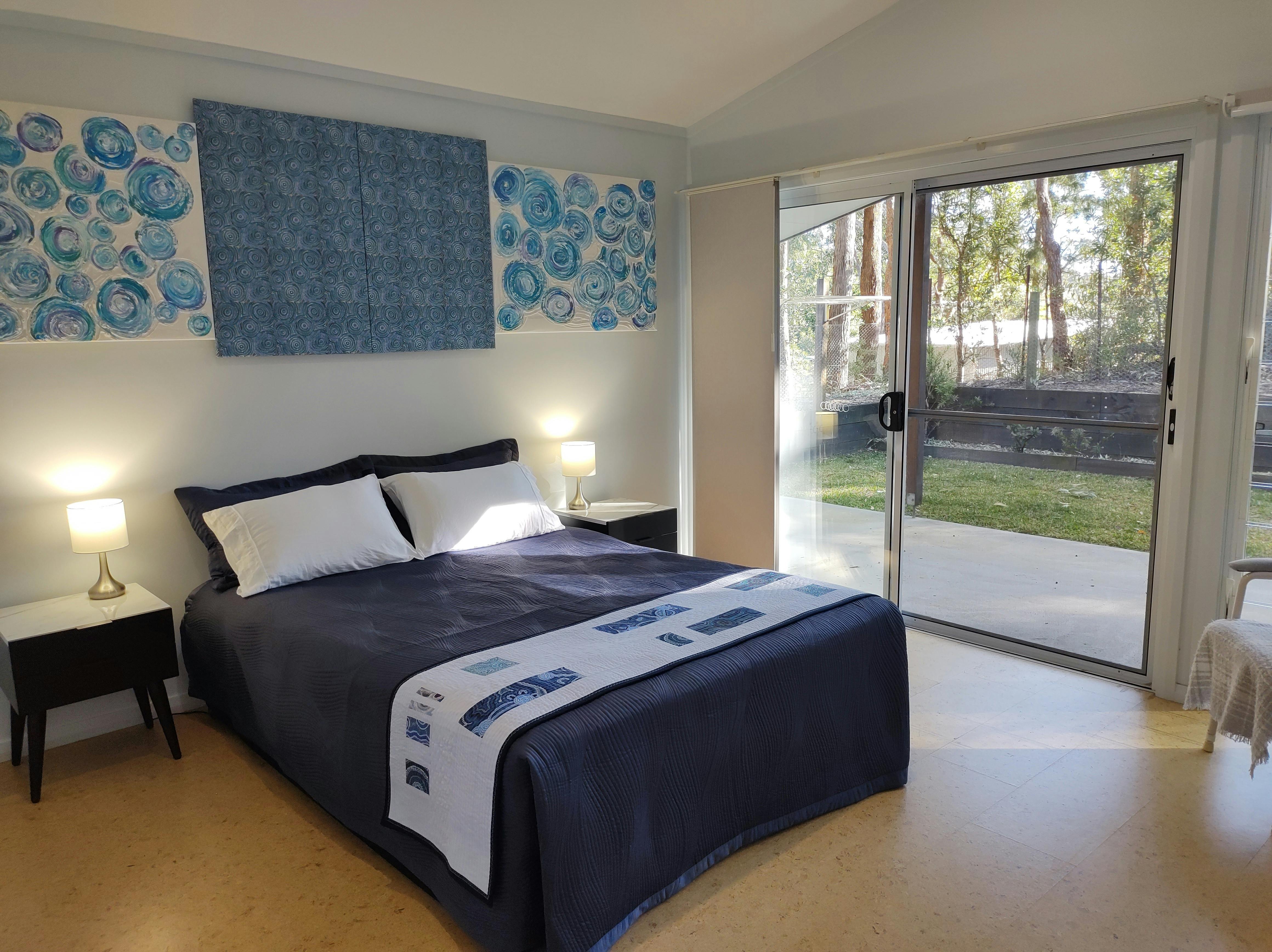 Large, roomy bedroom with a queen bed, touch lamps, built-in wardrobe and step-free external access