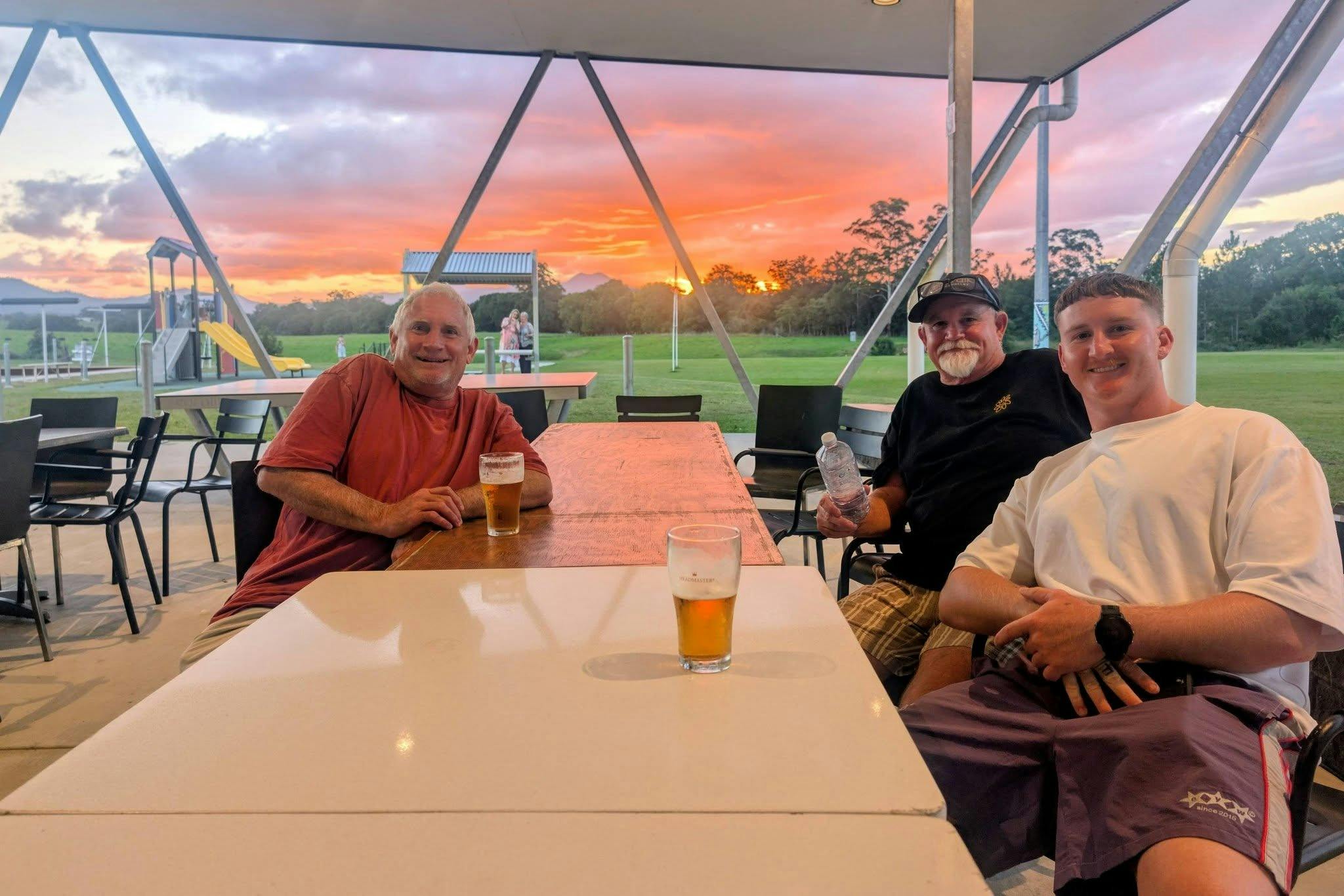 Patrons enjoying a beer and the view of the sun setting over the mountains of Bowraville
