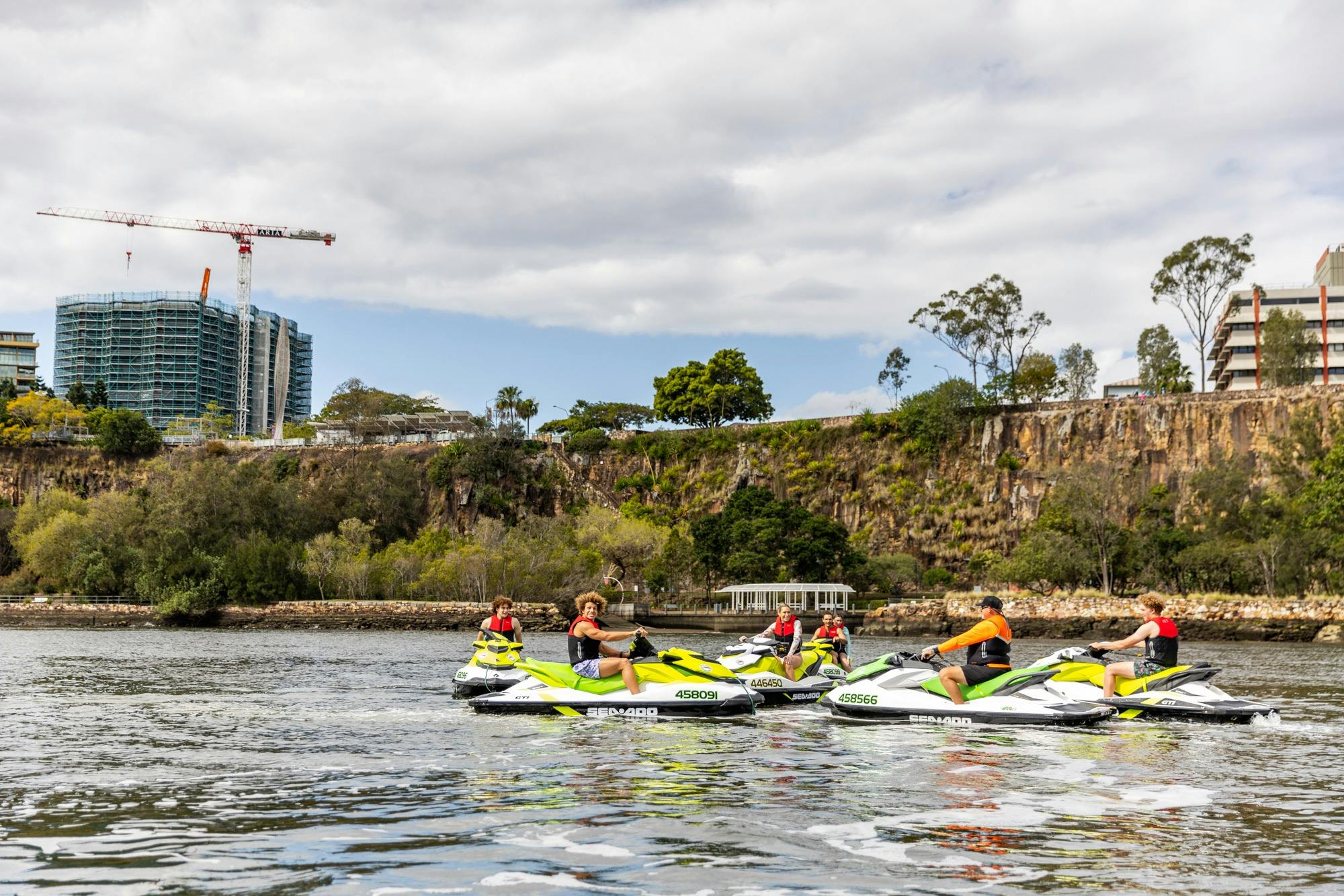 Group of people on jet skis looking at Kangaroon Cliffs from Brisbane River.