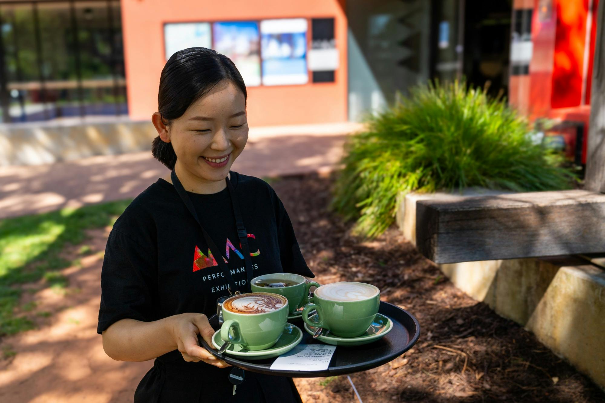 female, serving coffees outside