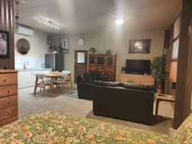 studio like room with kitchen, fridge, dining table, lounges, bed and TV.