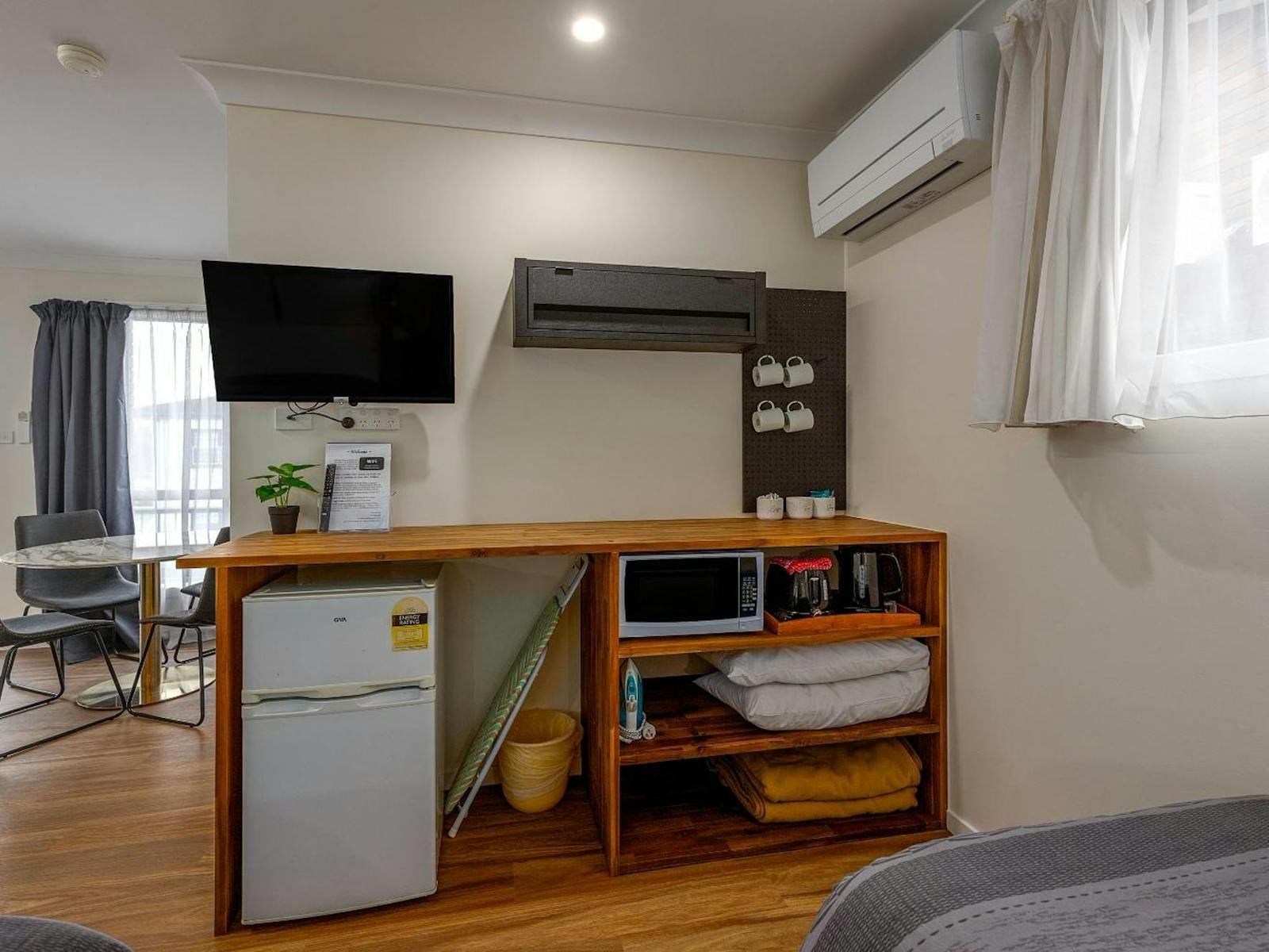 Open timber cupboard with kitchenette and tv