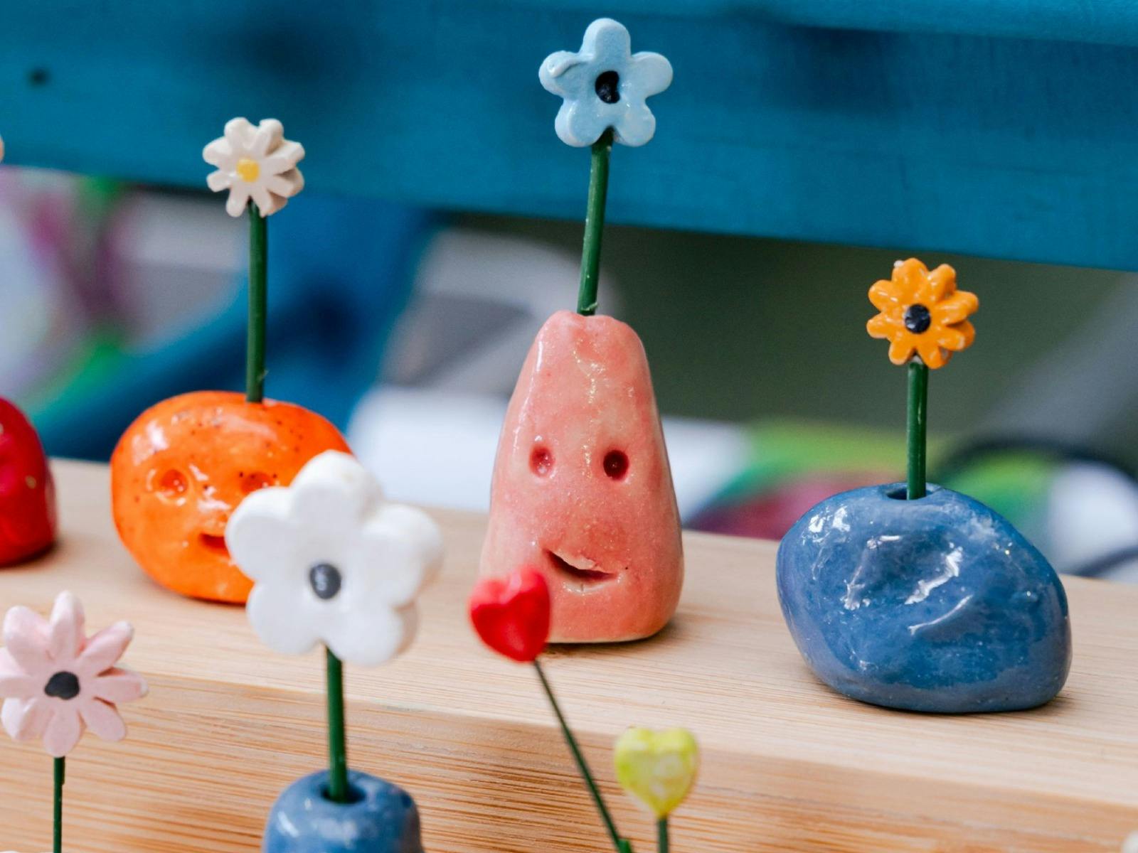 A close up of tiny ceramic vases with tiny ceramic flowers in each one