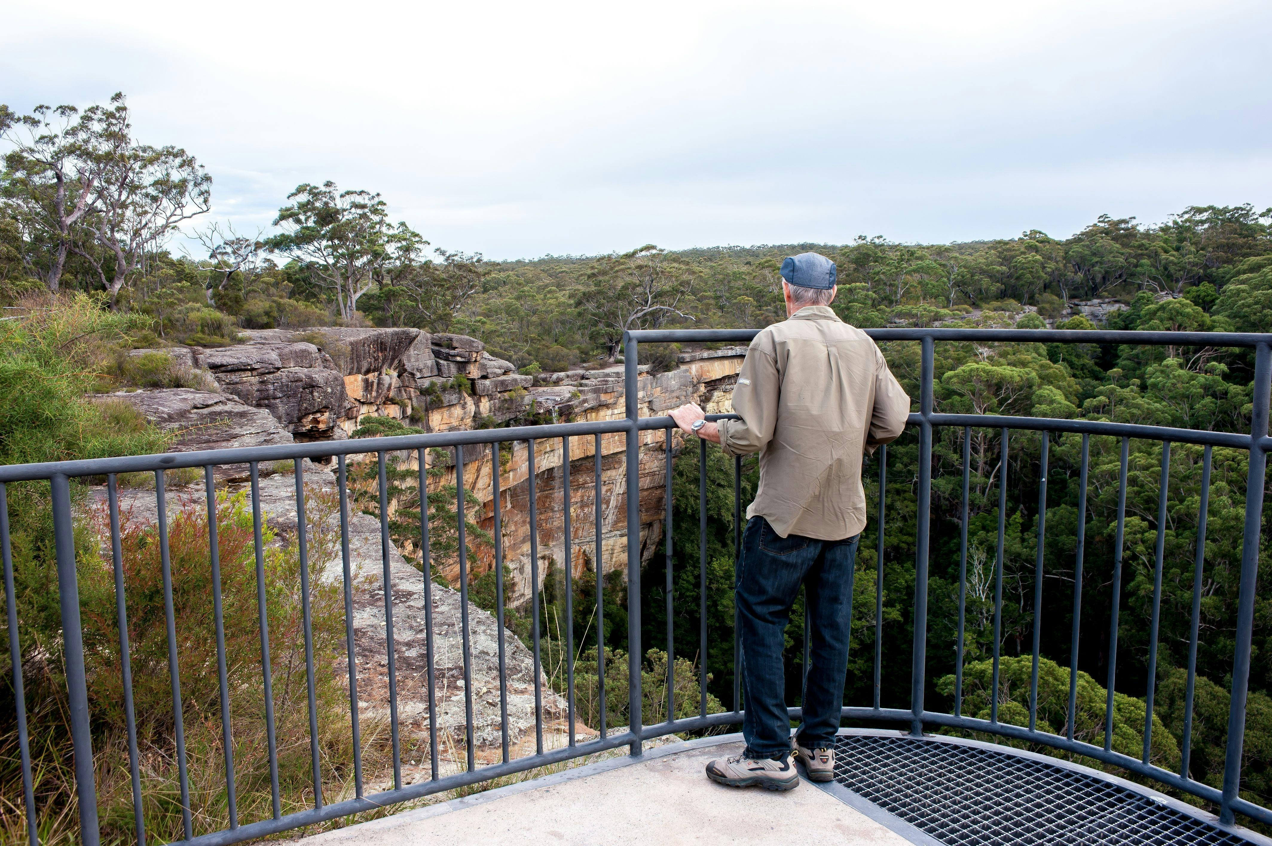 Man looking at Tianjara Falls from lookout in Morton National Park.
