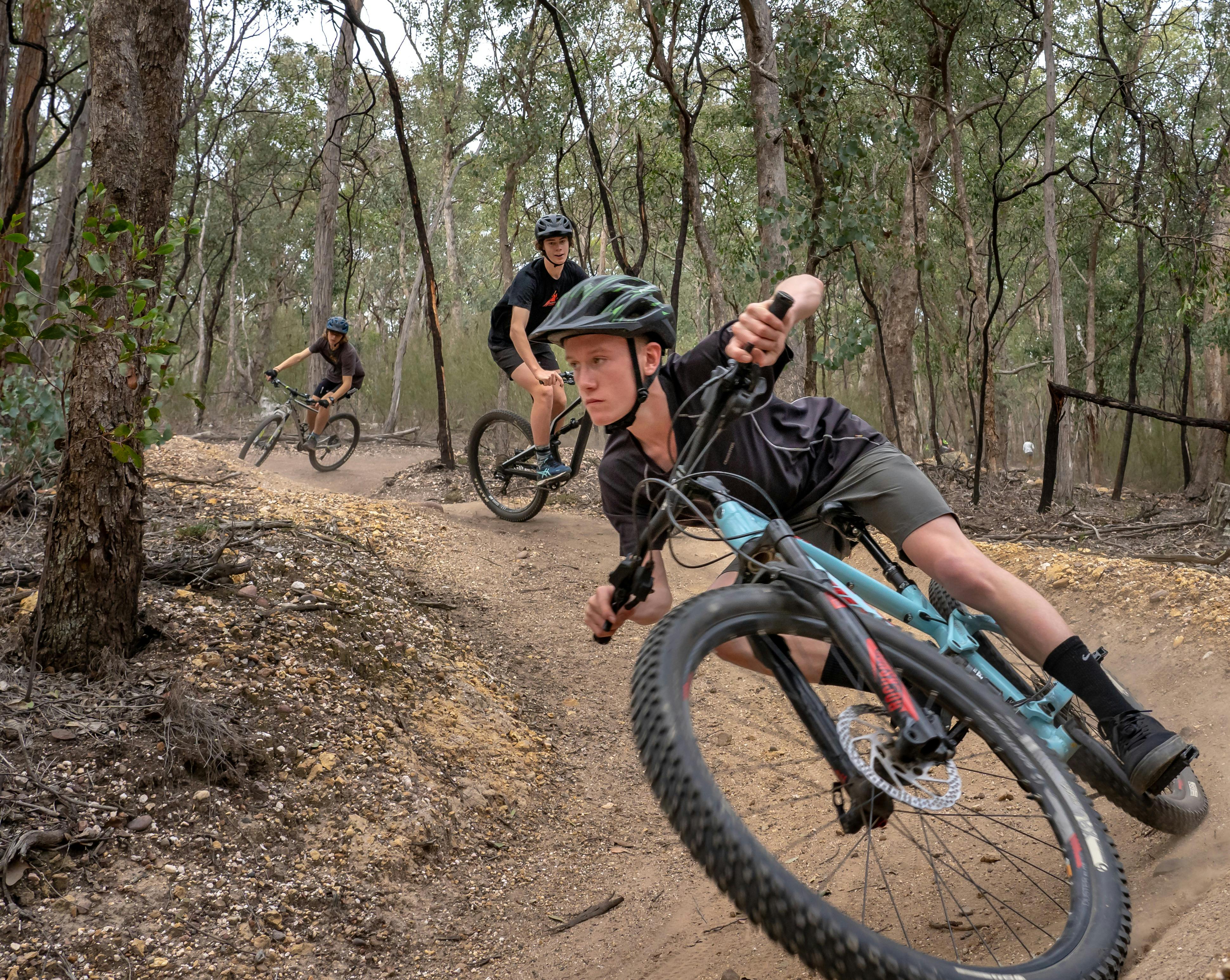 3 boys on mountain bike on a dirt track