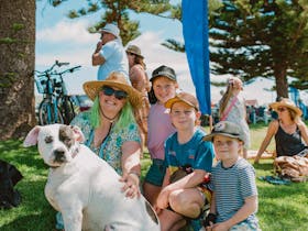 Family with pet dog on the foreshore lawns shaded by the Norfolk-pines.