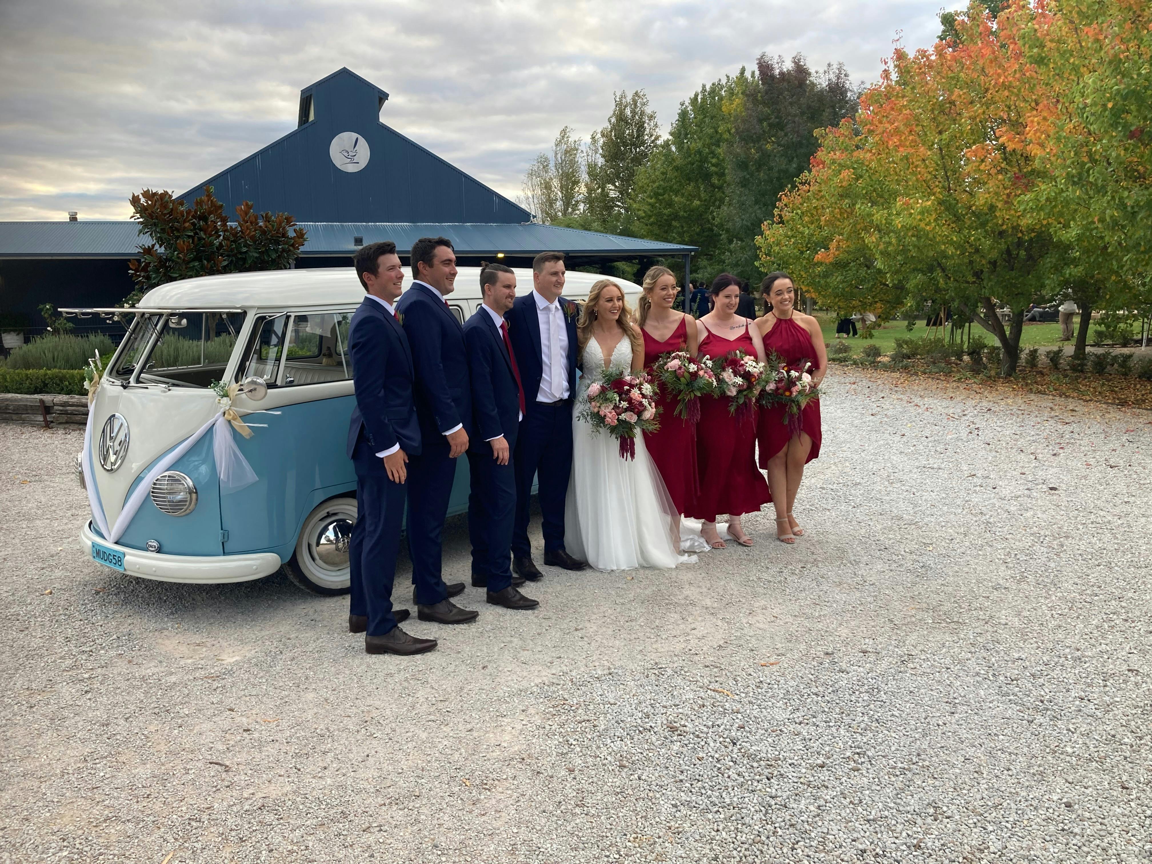 Wedding party beside blue Kombi