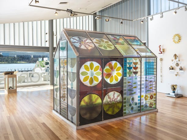 colourful glass greenhouse surrounded by other glass objects and artworks