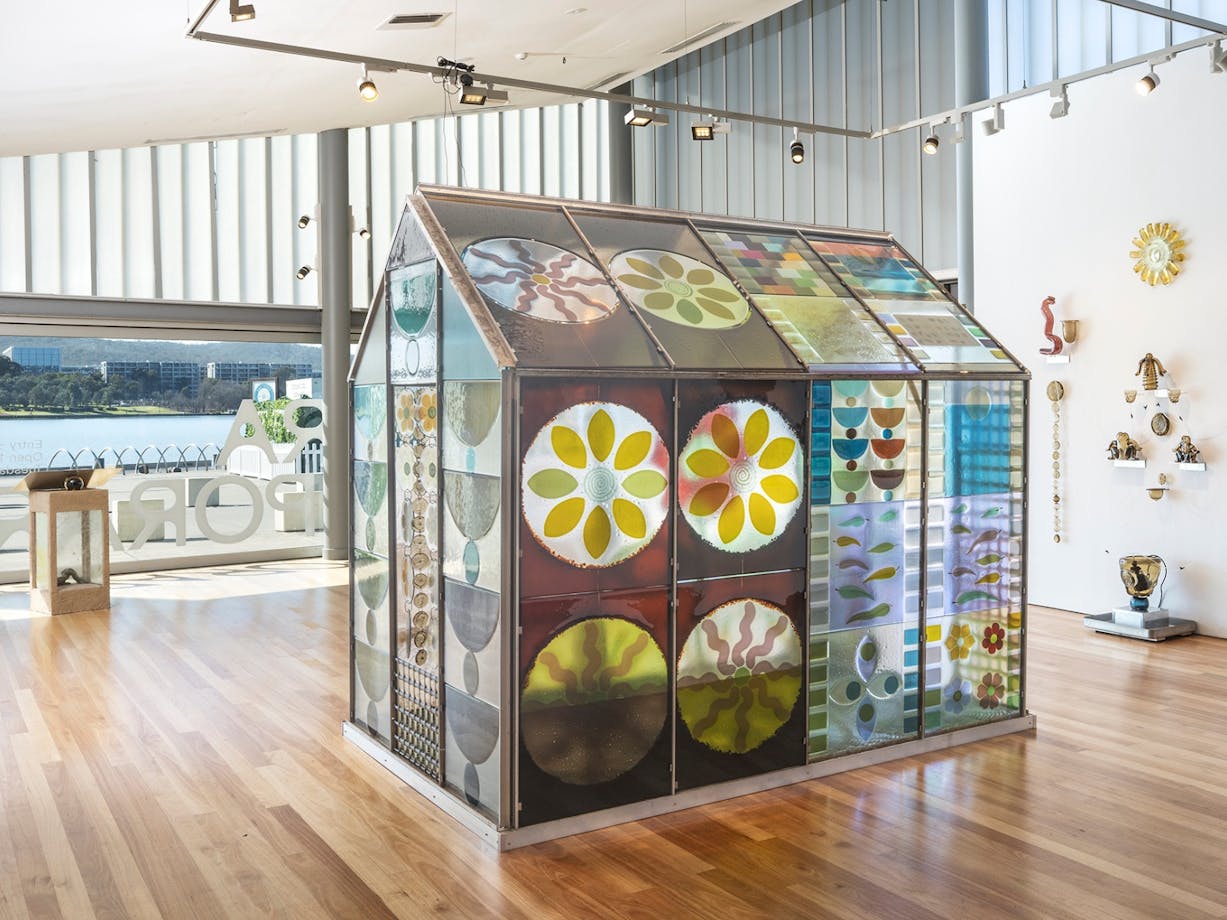 colourful glass greenhouse surrounded by other glass objects and artworks