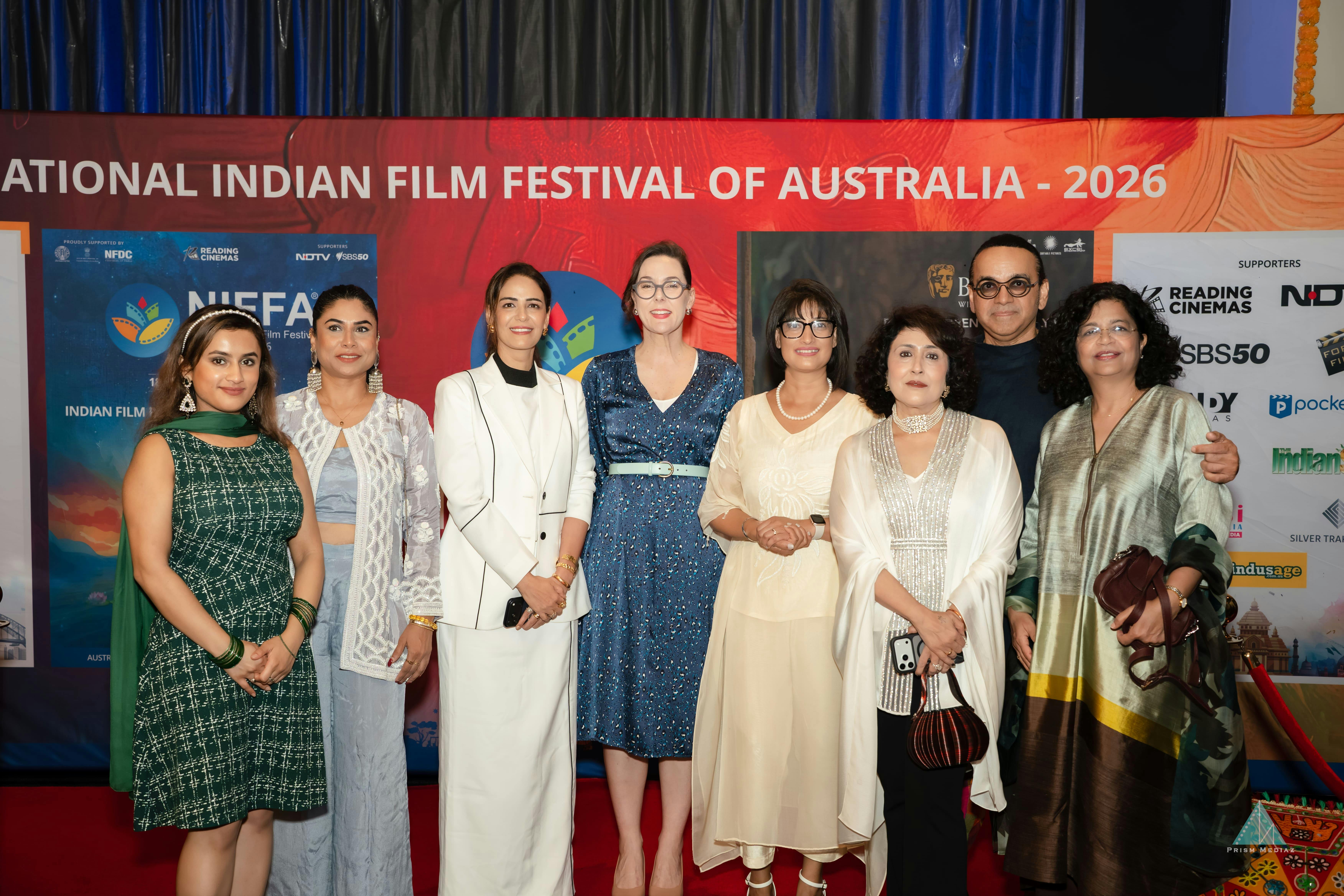 A group photo of NIFFA team and guests in front of the media wall during opening night red carpet e