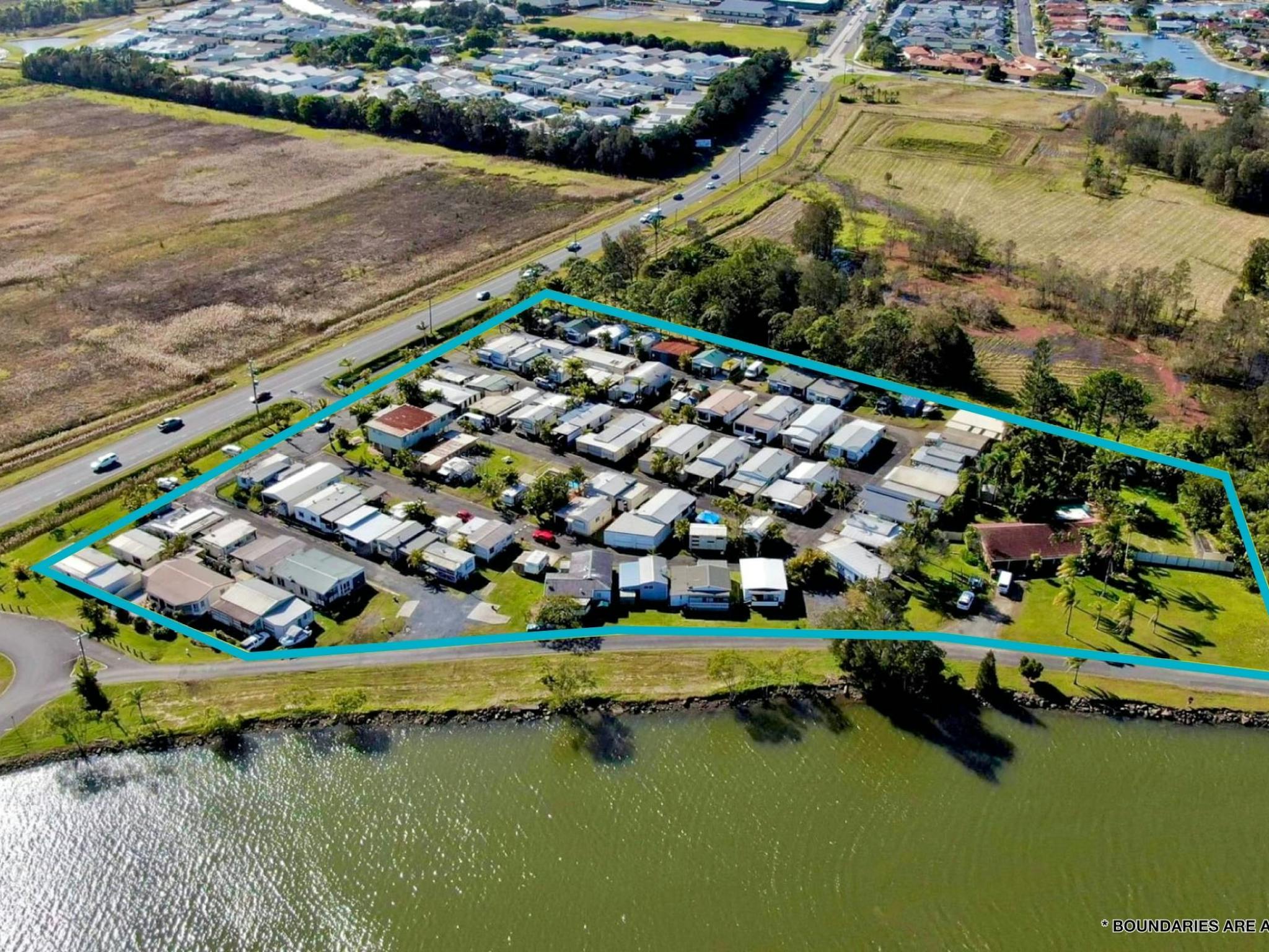 Aerial shot of a caravan park with the river on one side and major road on another