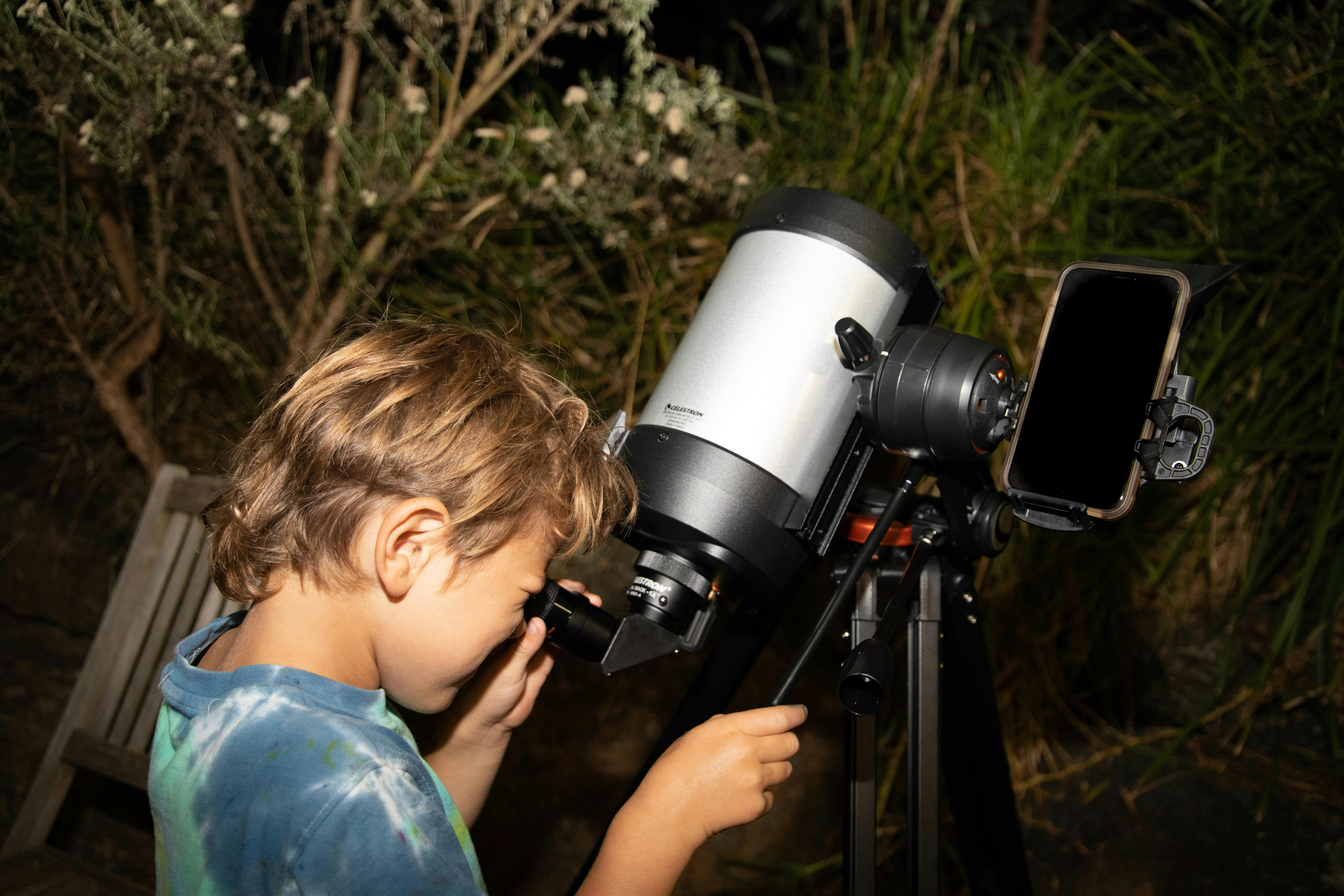 Child looking through the view finder of a telescope