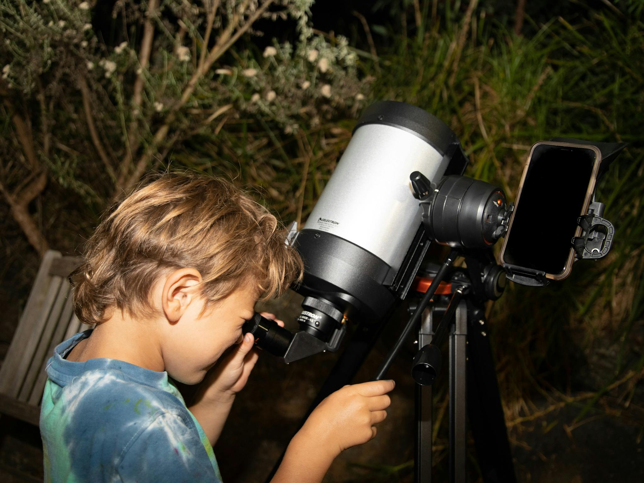 Child looking through the view finder of a telescope