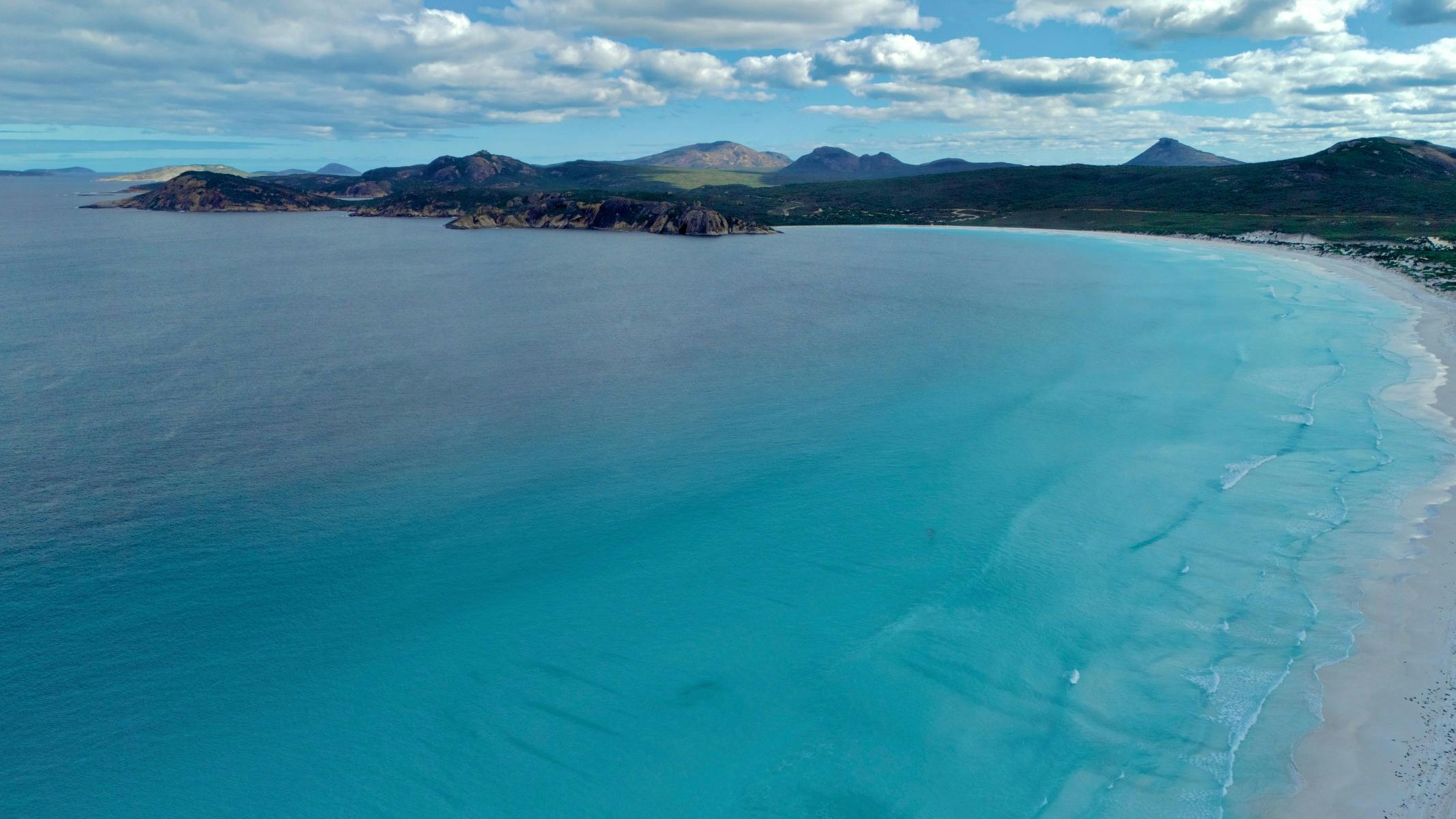 Drone photo over ocean to Lucky Bay Beach and beyond
