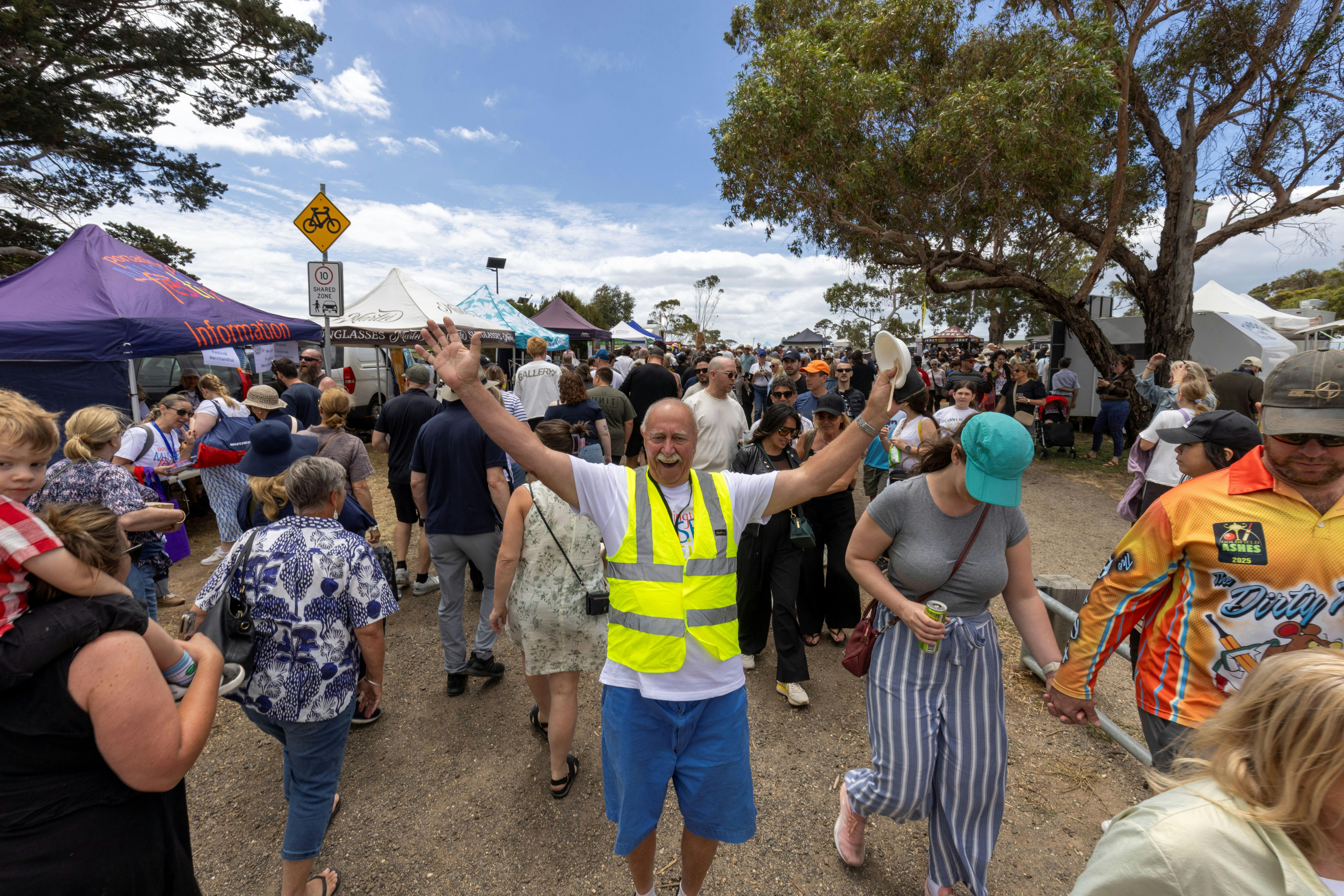 Volunteer waving to camera in a crowd