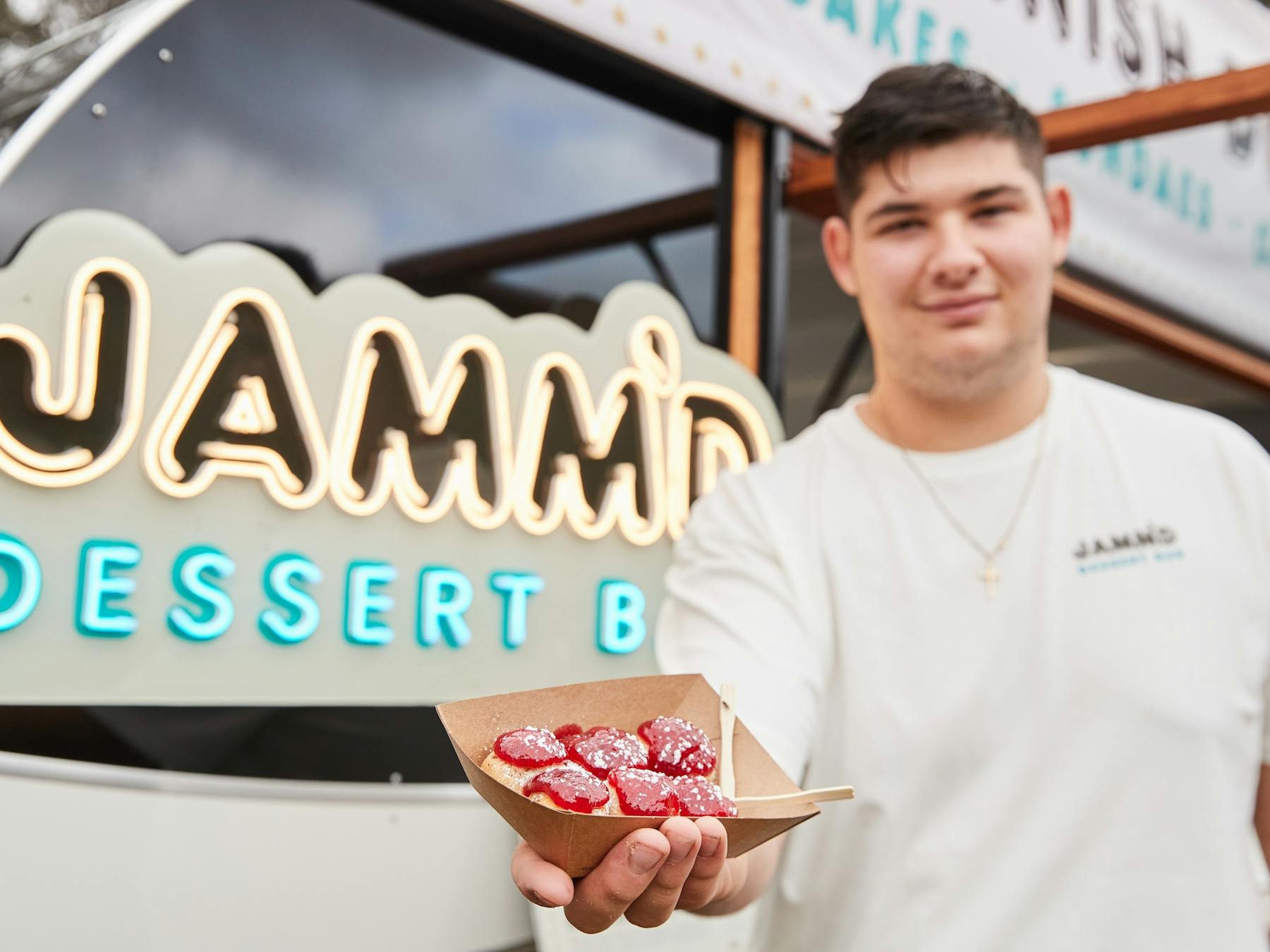Man holding a tray of jam donuts from Jamm'd Dessert Bar food truck at Grampians Grape Escape
