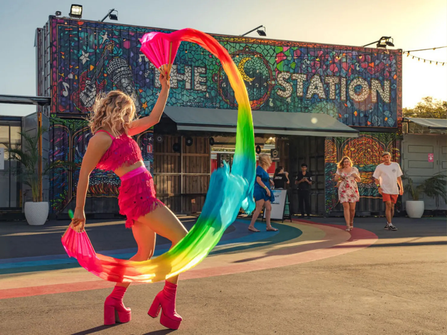 Lady dancing at the main entrance with colourful flags