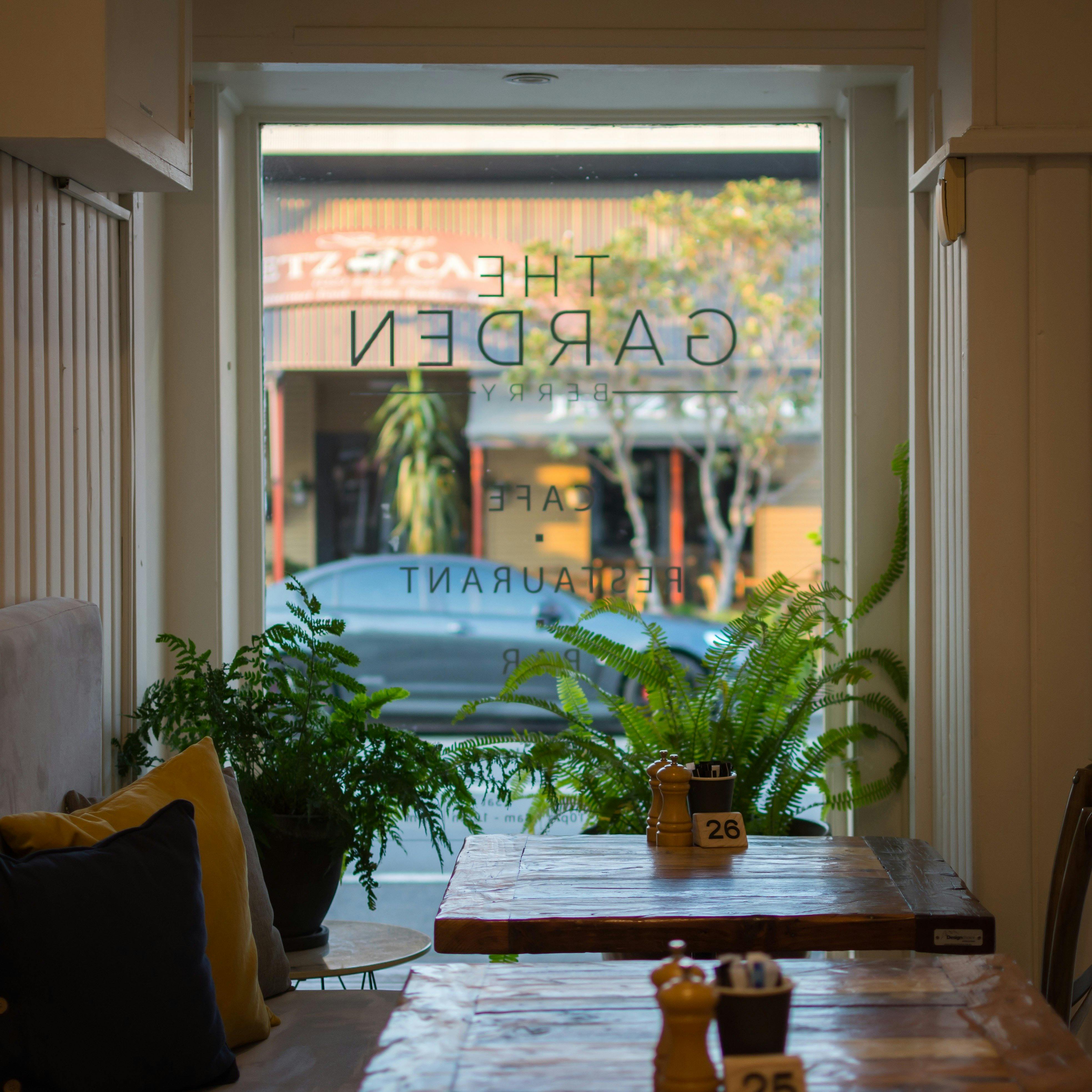 窓際の居心地の良いベンチ席、新鮮な緑/シダがたくさん