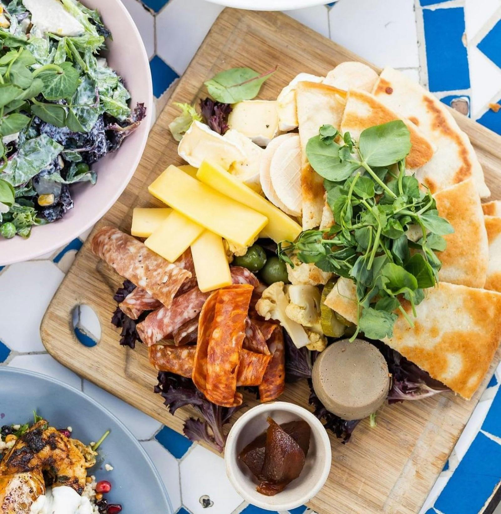A platter of food presented on a wooden board.