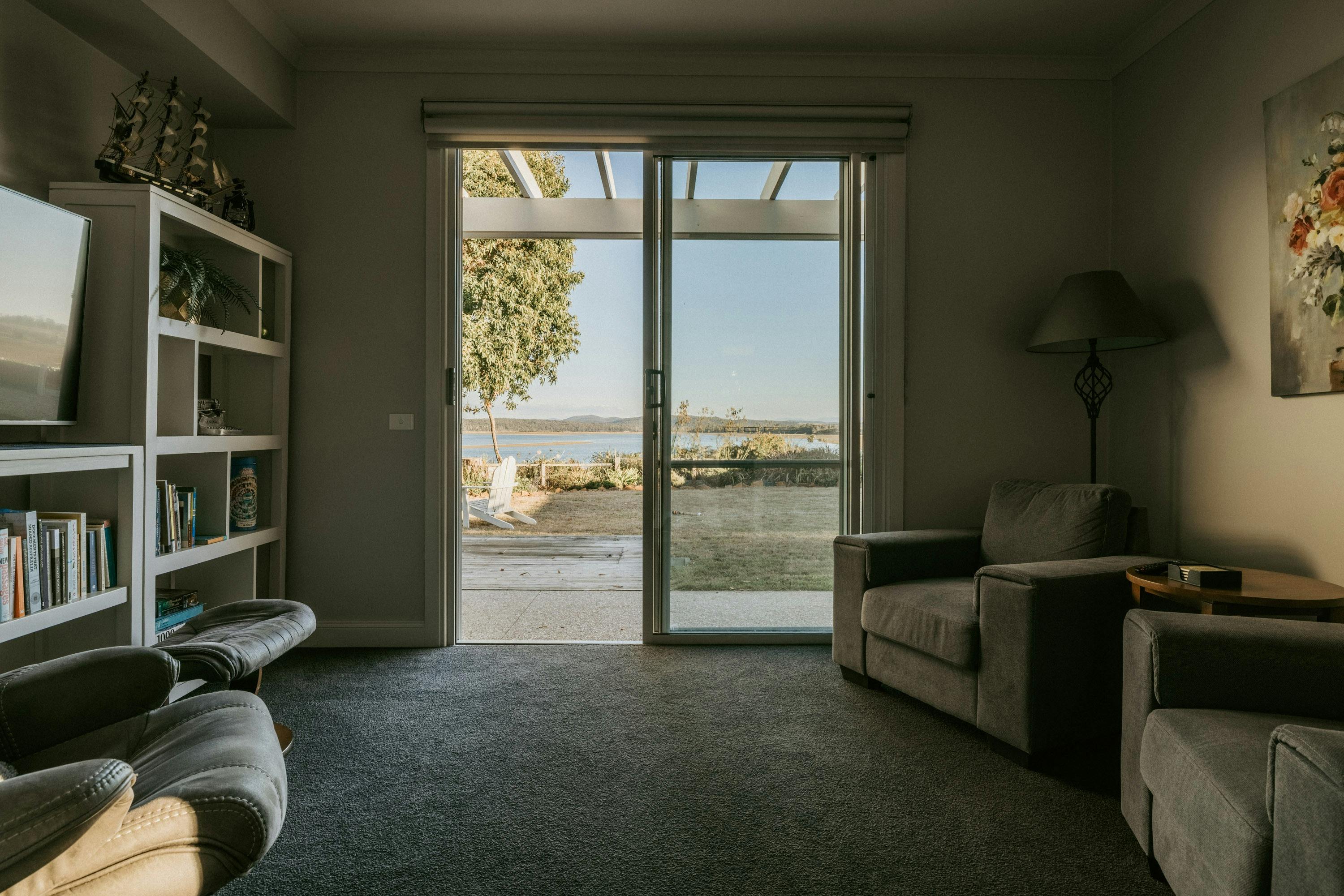 This room is a cosy space with comfortable chairs, a Smart TV, and a selection of books to  enjoy.