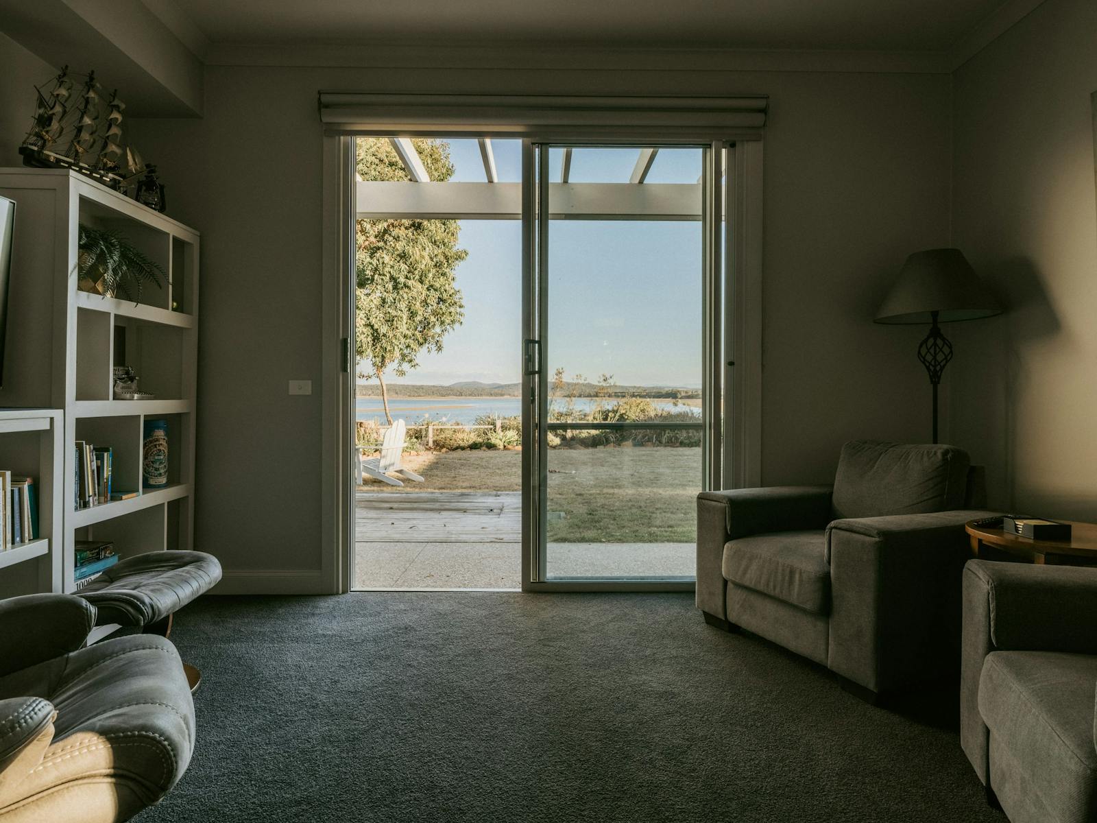 This room is a cosy space with comfortable chairs, a Smart TV, and a selection of books to  enjoy.