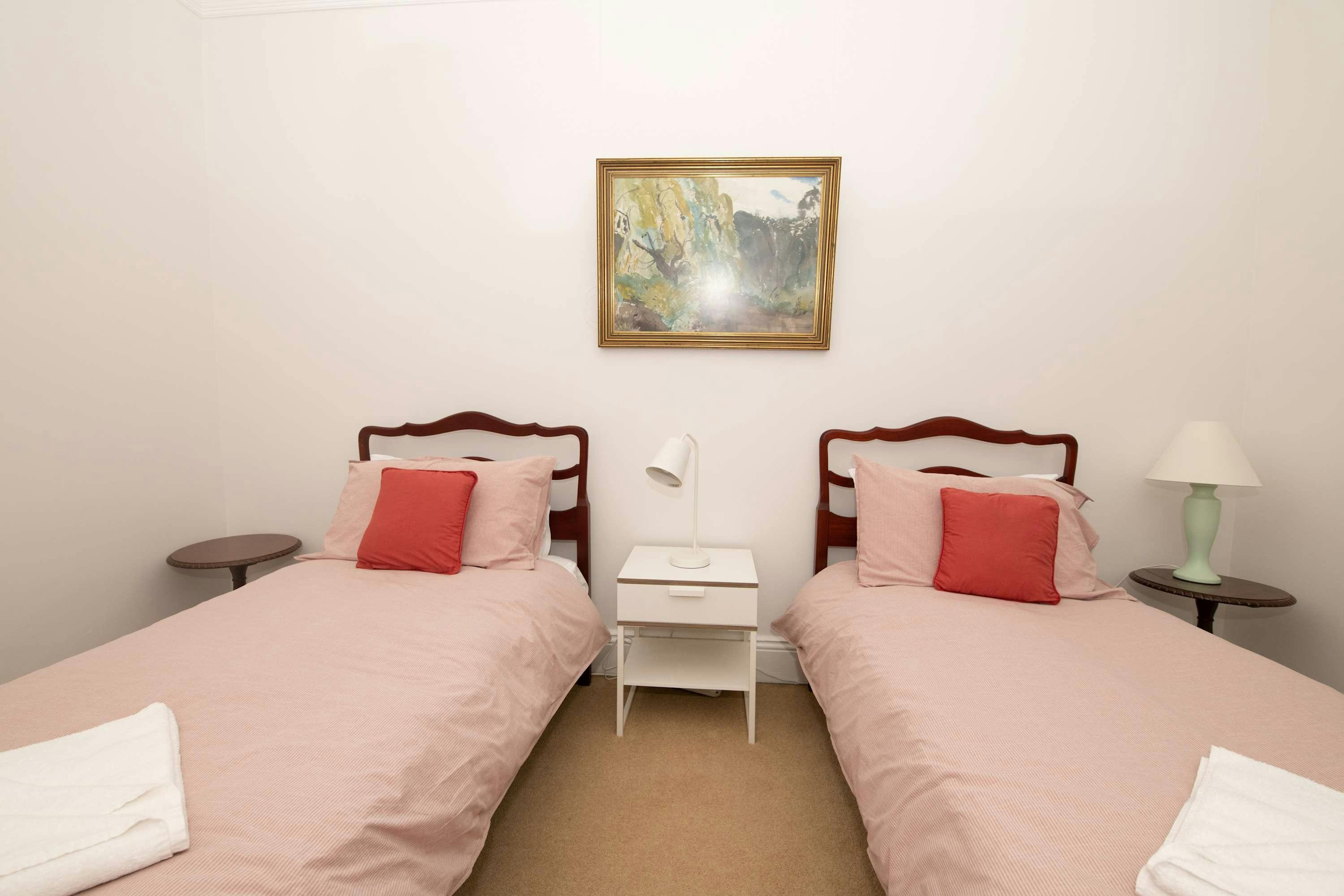 핑크색 이불과 베개가 놓인 싱글 침대