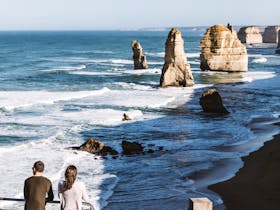 Two people looking out onto the Twelve Apostles along Great Ocean Road.
