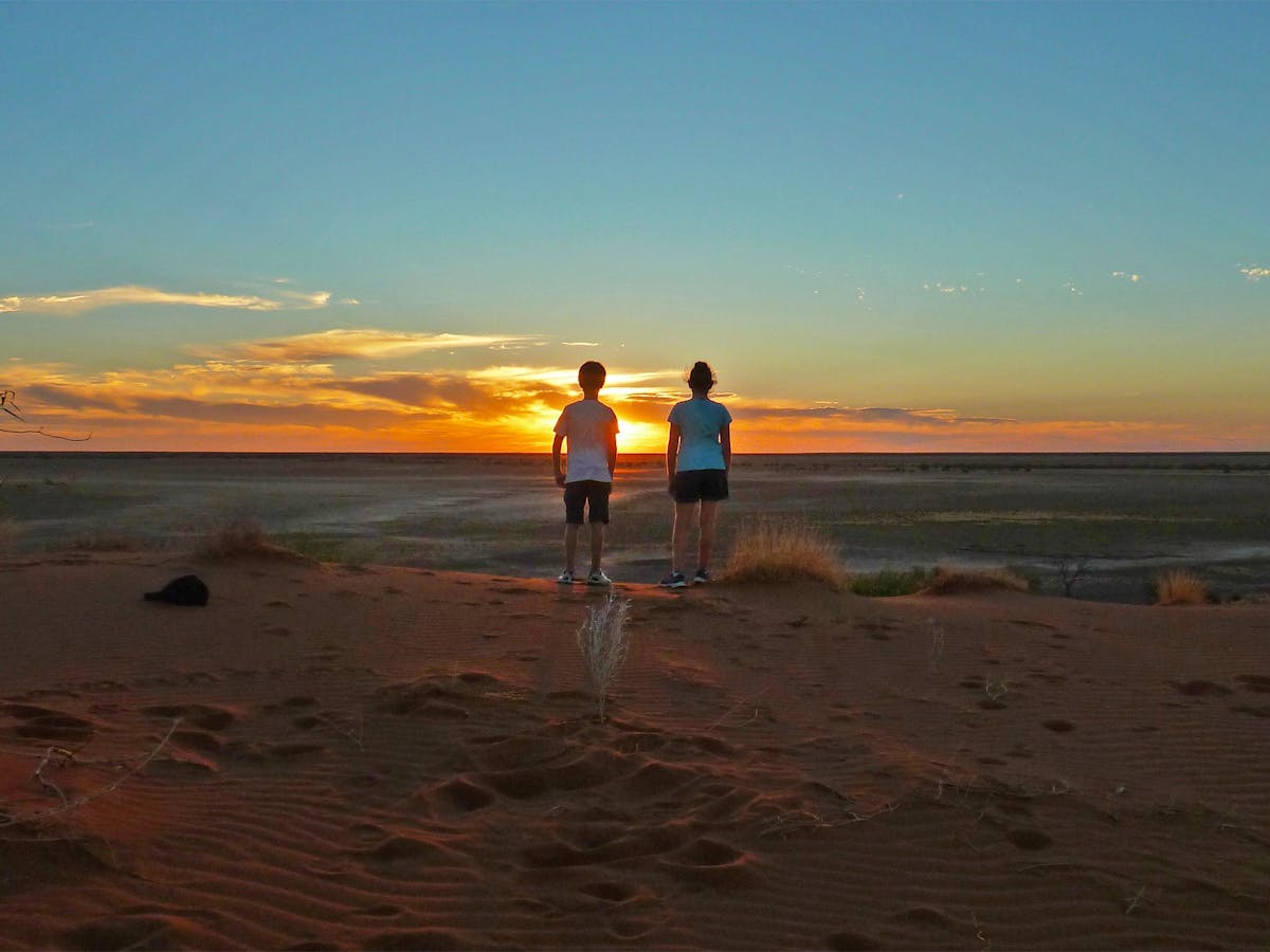 Children watching sunset on sandune. Children watching sunset on sandune.