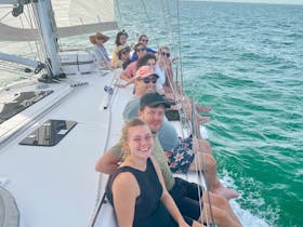 Guests enjoying sitting on the rail while sailing